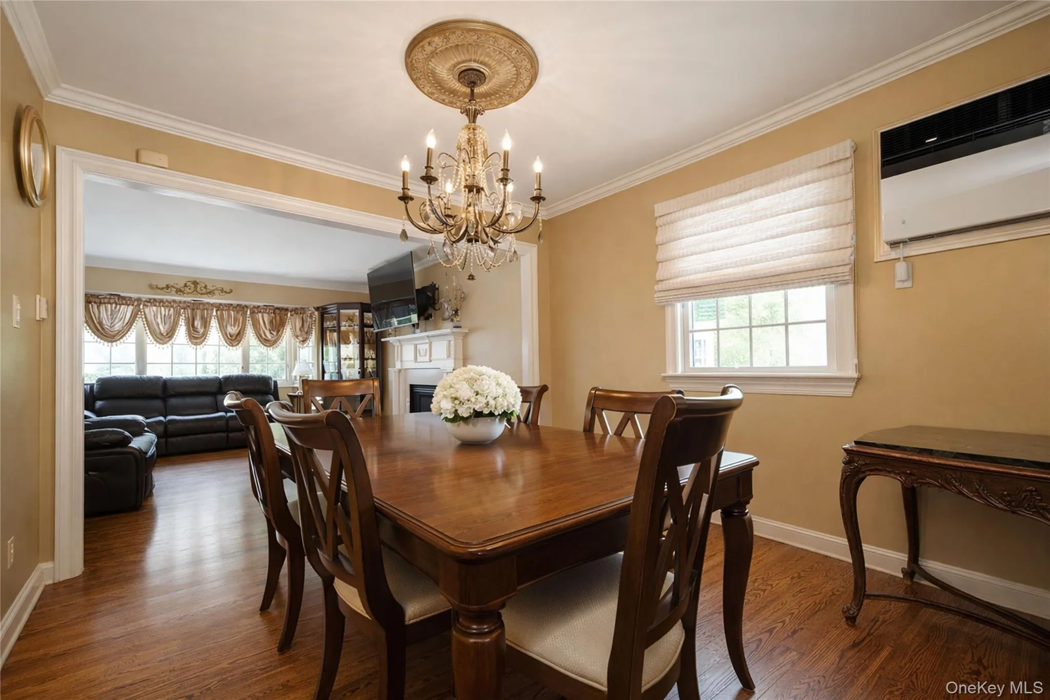 Formal dining area featuring wood-finish flooring, white crown molding, and a decorative ceiling medallion with a chandelier Formal dining area featuring wood-finish flooring, white crown molding, and a decorative ceiling medallion with a chandelier