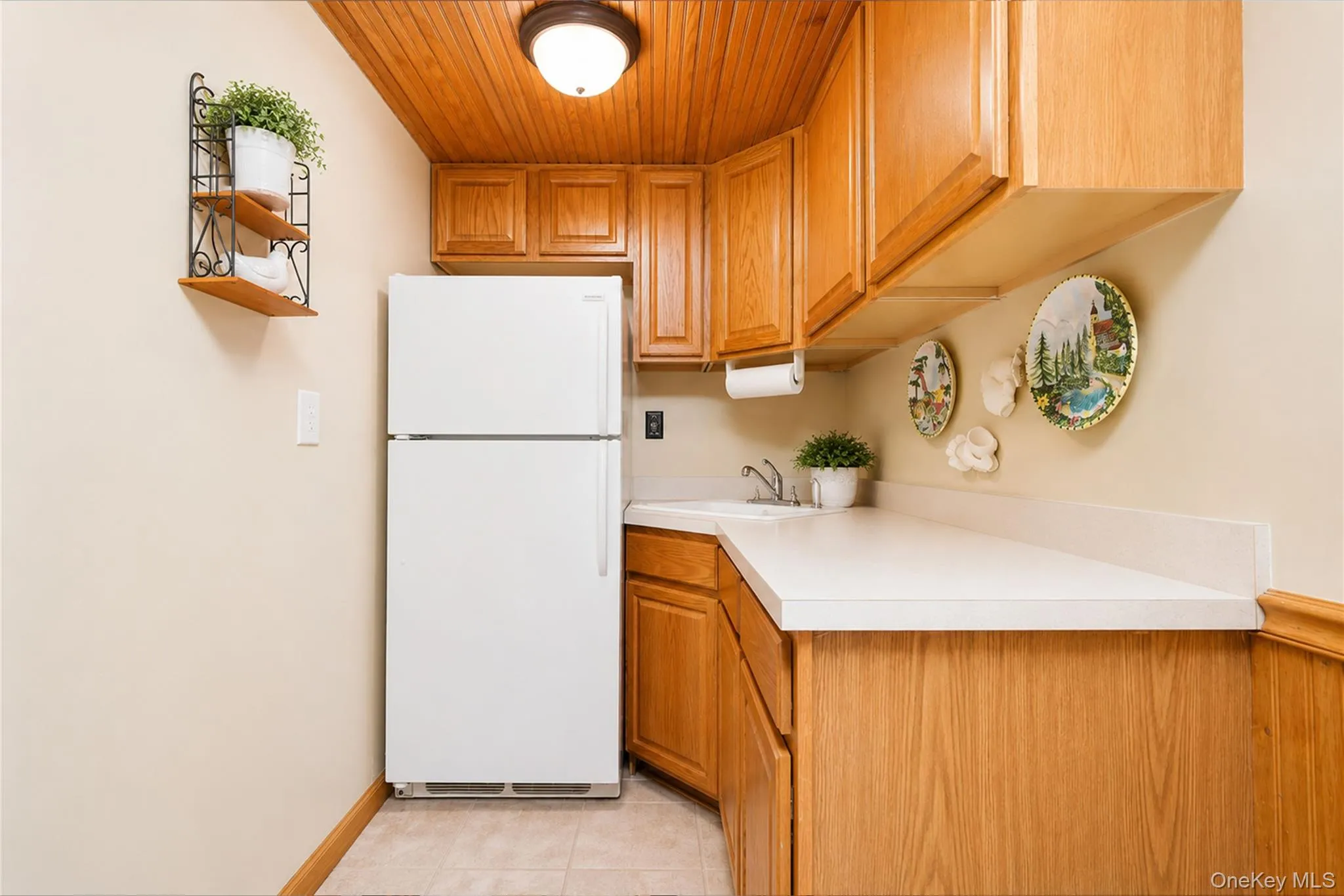 Compact area featuring wood cabinetry and white countertops Compact area featuring wood cabinetry and white countertops