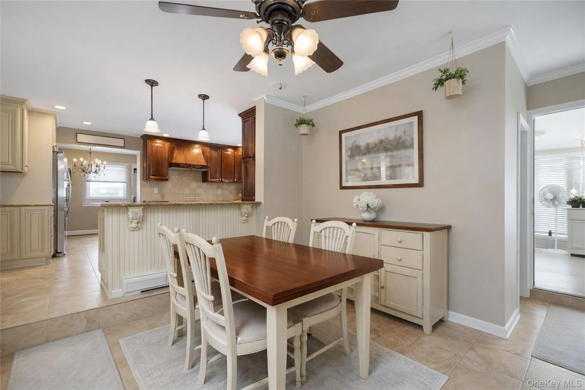 Dining area featuring a ceiling fan, crown molding, and tiled flooring Dining area featuring a ceiling fan, crown molding, and tiled flooring