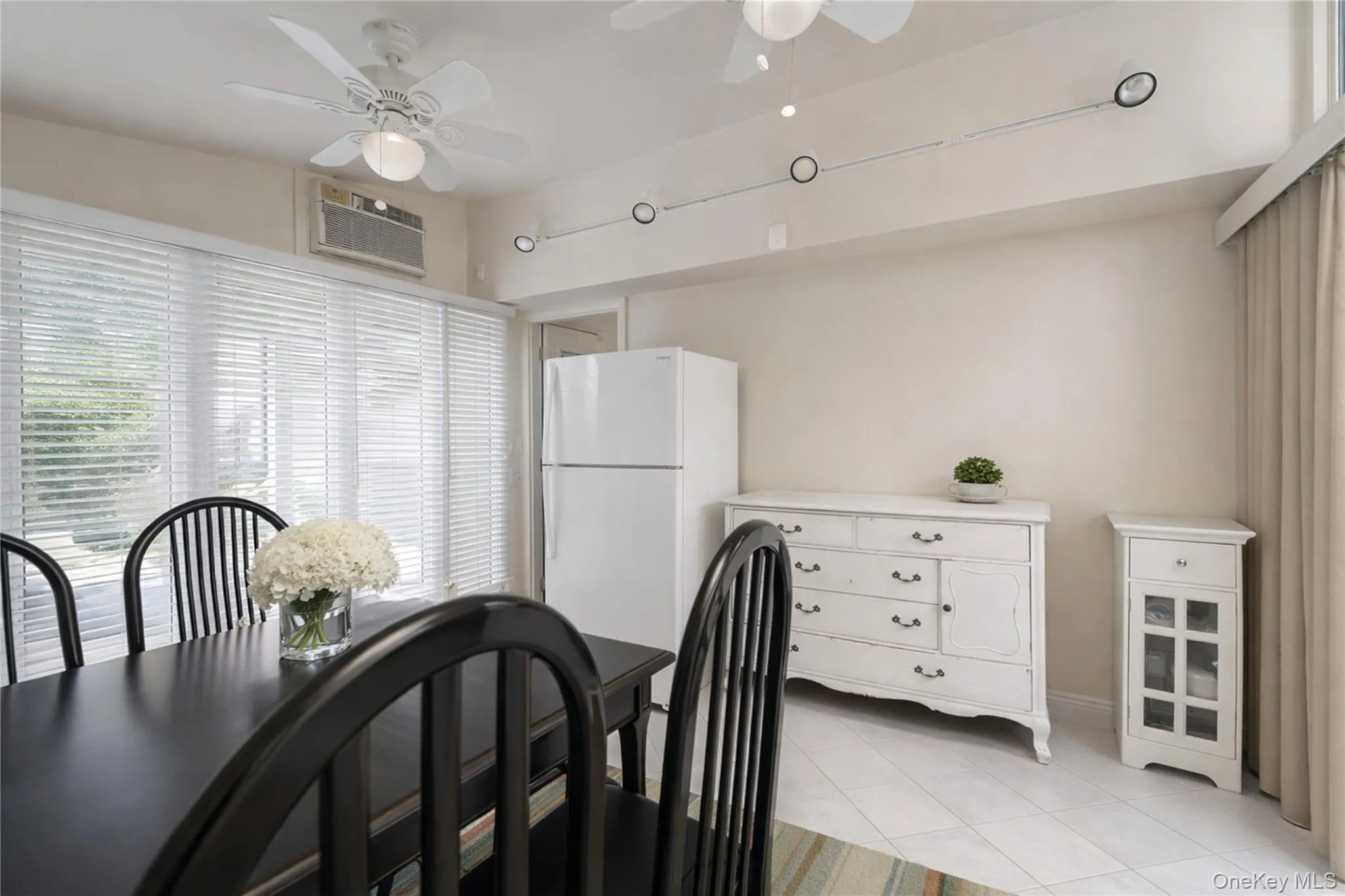 Dining area featuring white ceramic tile flooring and light beige wall paint Dining area featuring white ceramic tile flooring and light beige wall paint
