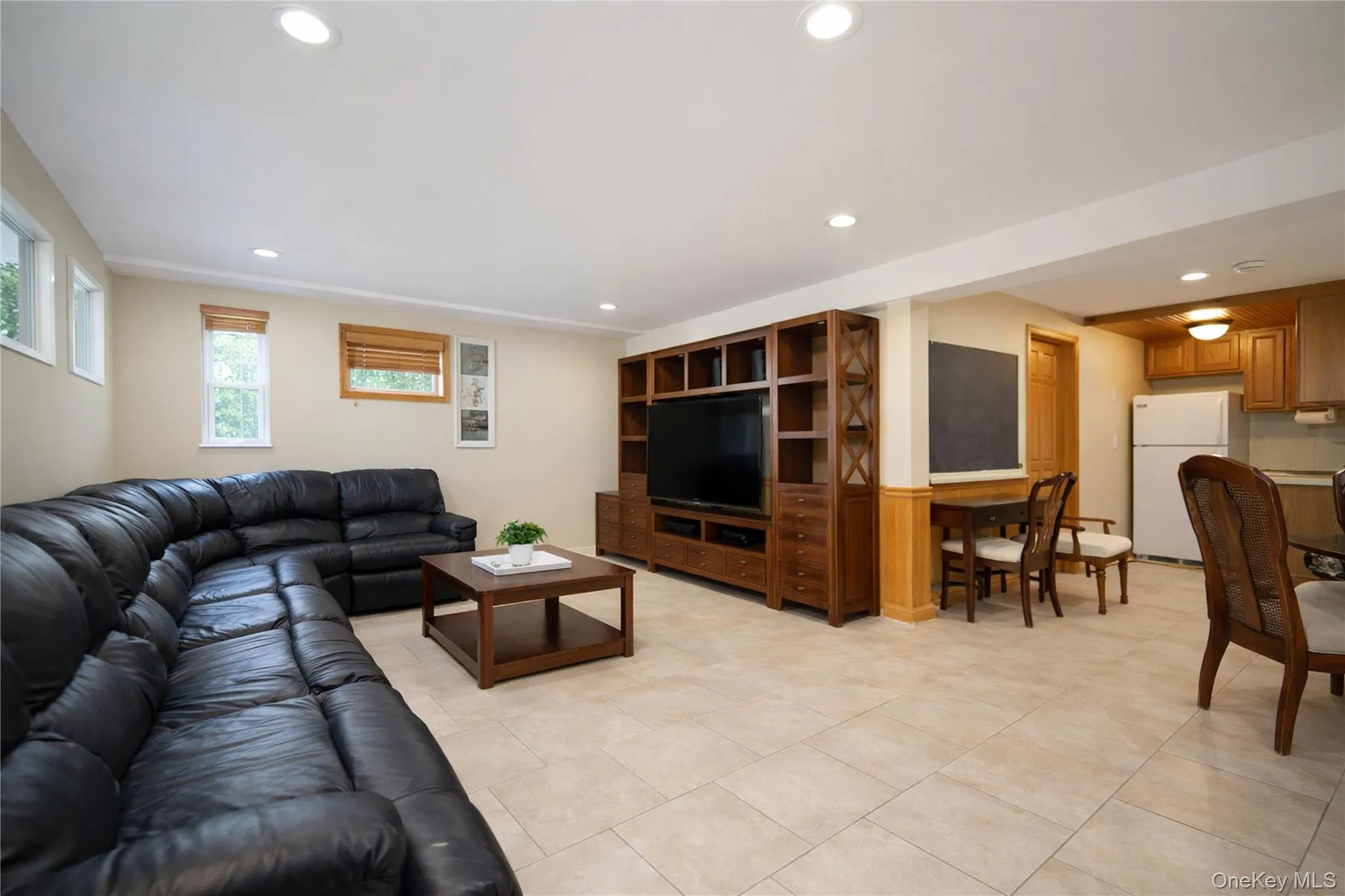 Open-concept living space featuring recessed lighting, light-toned tile flooring, and multiple windows Open-concept living space featuring recessed lighting, light-toned tile flooring, and multiple windows