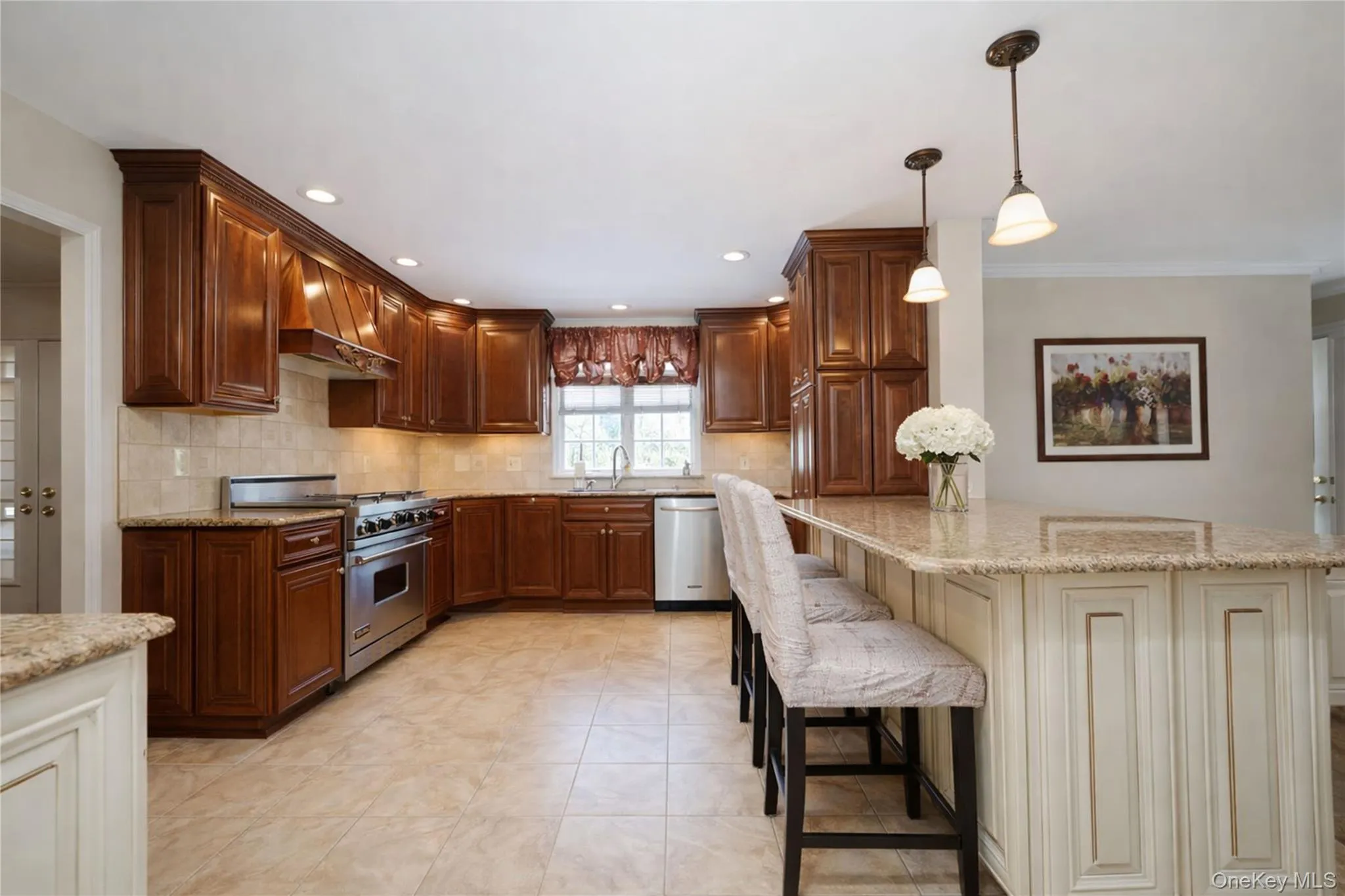 Spacious kitchen featuring rich wood cabinetry, stainless steel range with hood, integrated dishwasher, and a center island with pendant lighting and seating Spacious kitchen featuring rich wood cabinetry, stainless steel range with hood, integrated dishwasher, and a center island with pendant lighting and seating