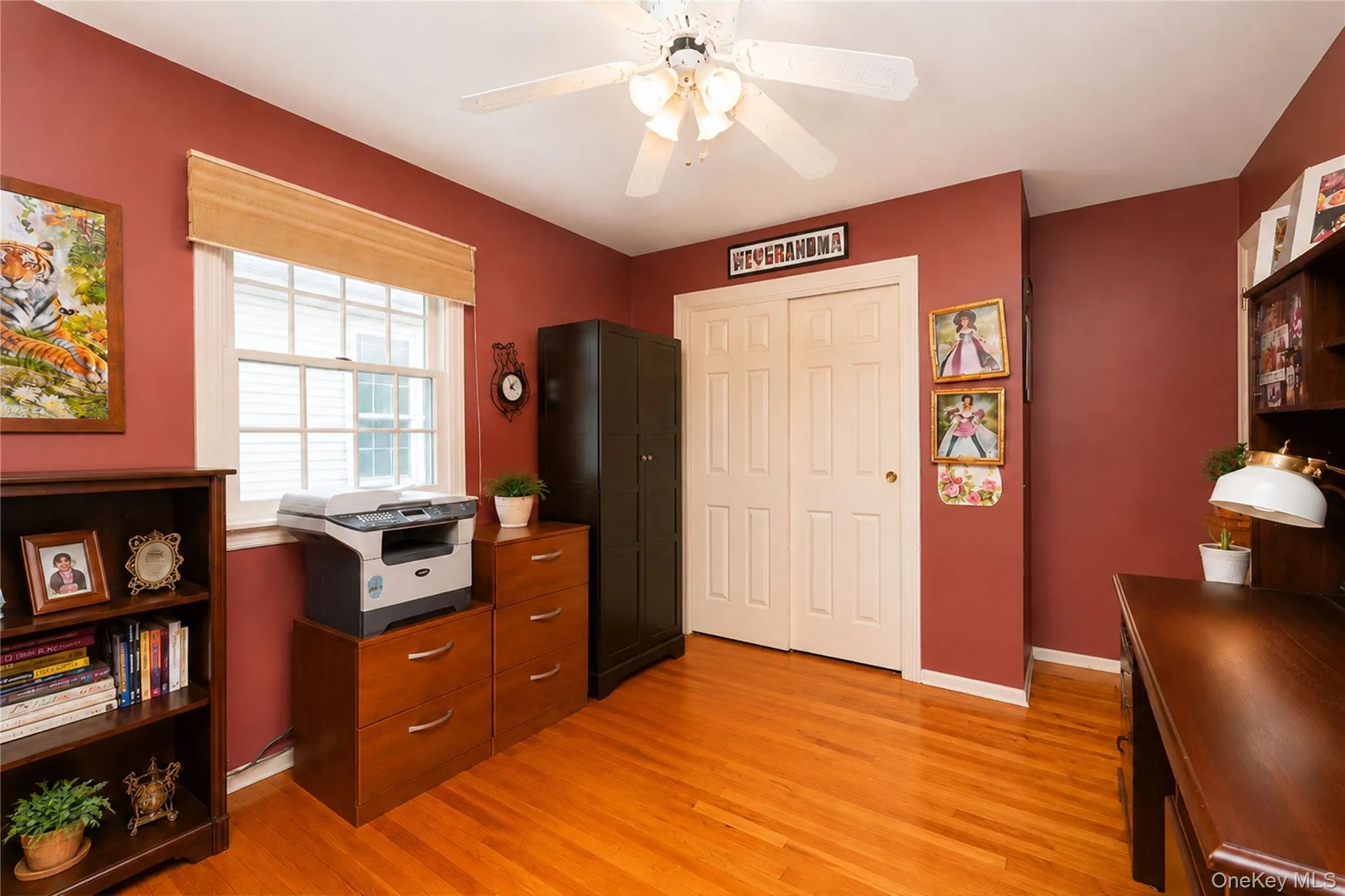Room with hardwood flooring, a ceiling fan, and a double-hung window Room with hardwood flooring, a ceiling fan, and a double-hung window