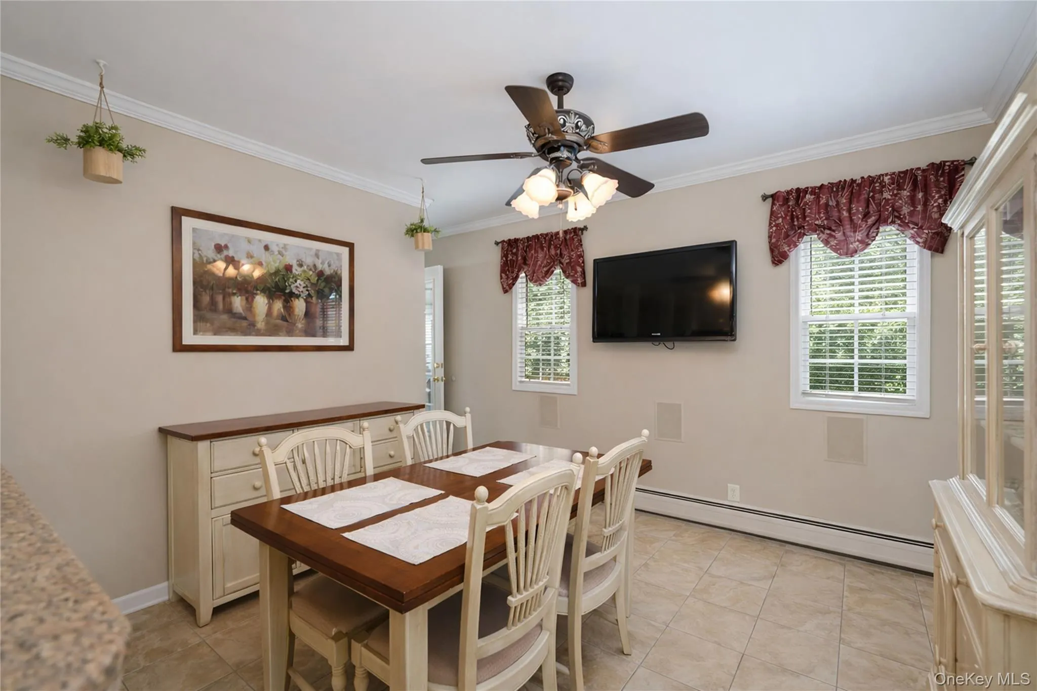 Dining area featuring tile flooring, crown molding, and two windows with blinds Dining area featuring tile flooring, crown molding, and two windows with blinds