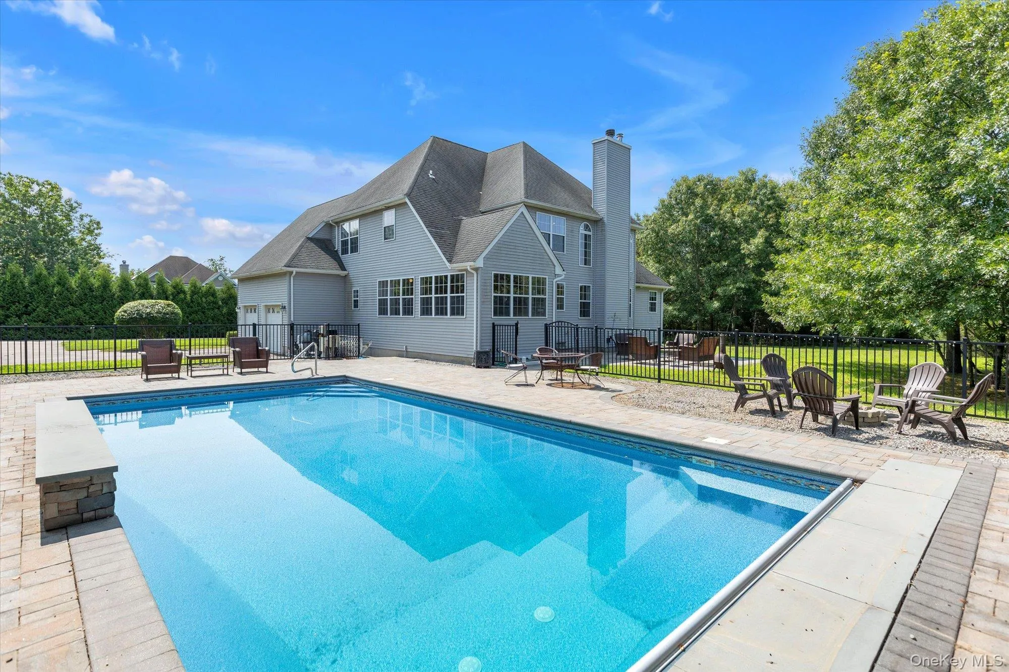 Spacious backyard featuring a rectangular, heated in-ground pool, paver patio, black metal fencing Spacious backyard featuring a rectangular, heated in-ground pool, paver patio, black metal fencing
