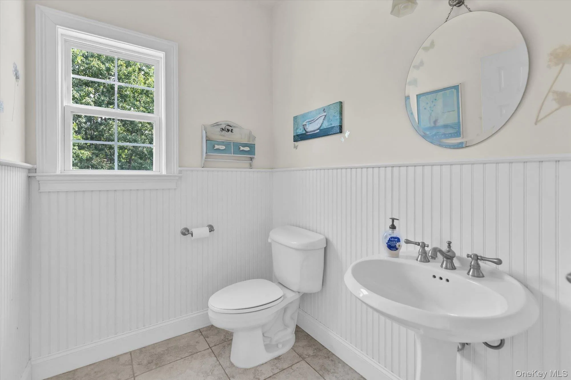 White beadboard paneling, pedestal sink, chrome faucet, and tiled flooring White beadboard paneling, pedestal sink, chrome faucet, and tiled flooring
