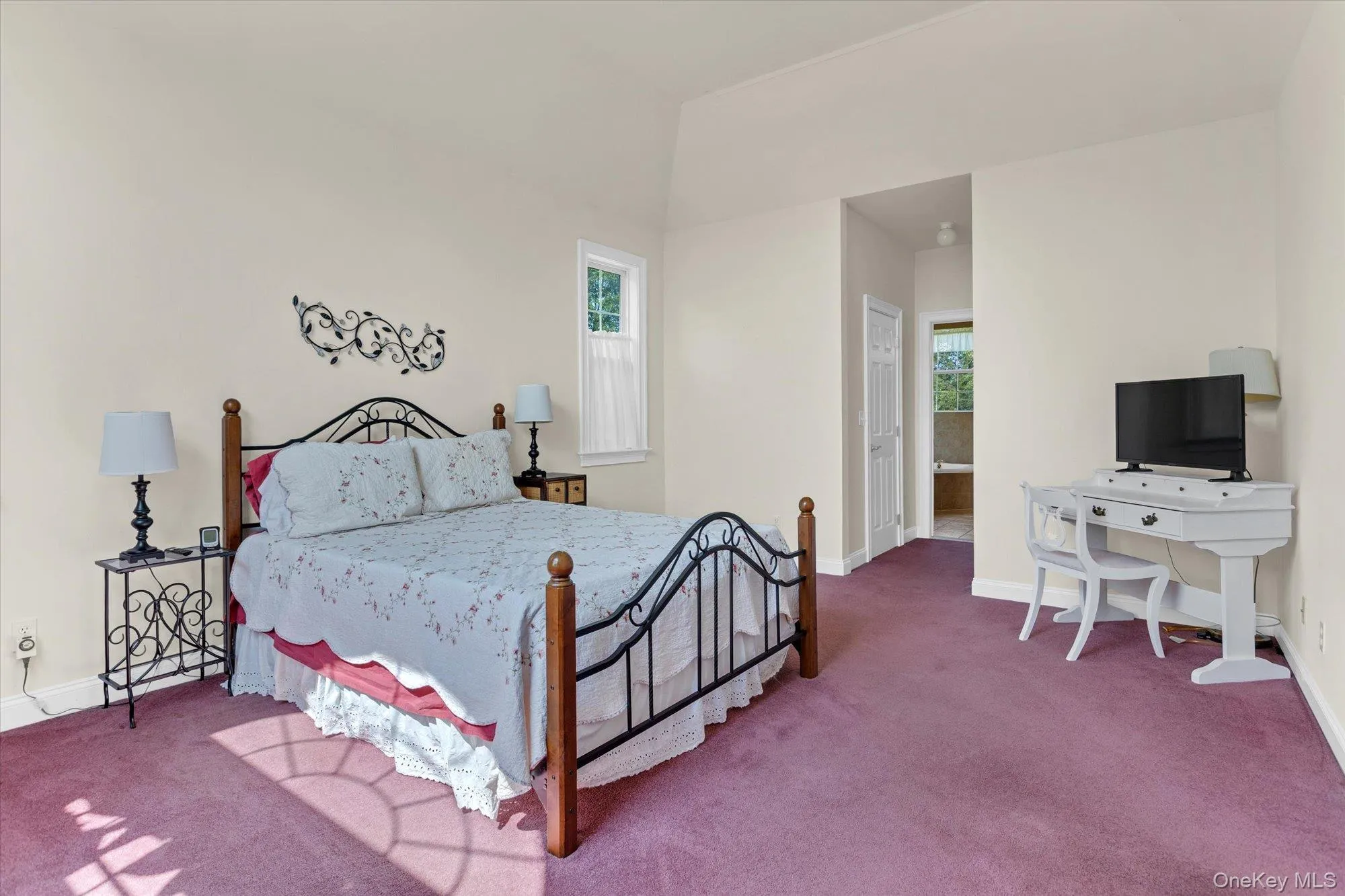 Vaulted ceiling, wall-to-wall carpeting, and an arched doorway Vaulted ceiling, wall-to-wall carpeting, and an arched doorway