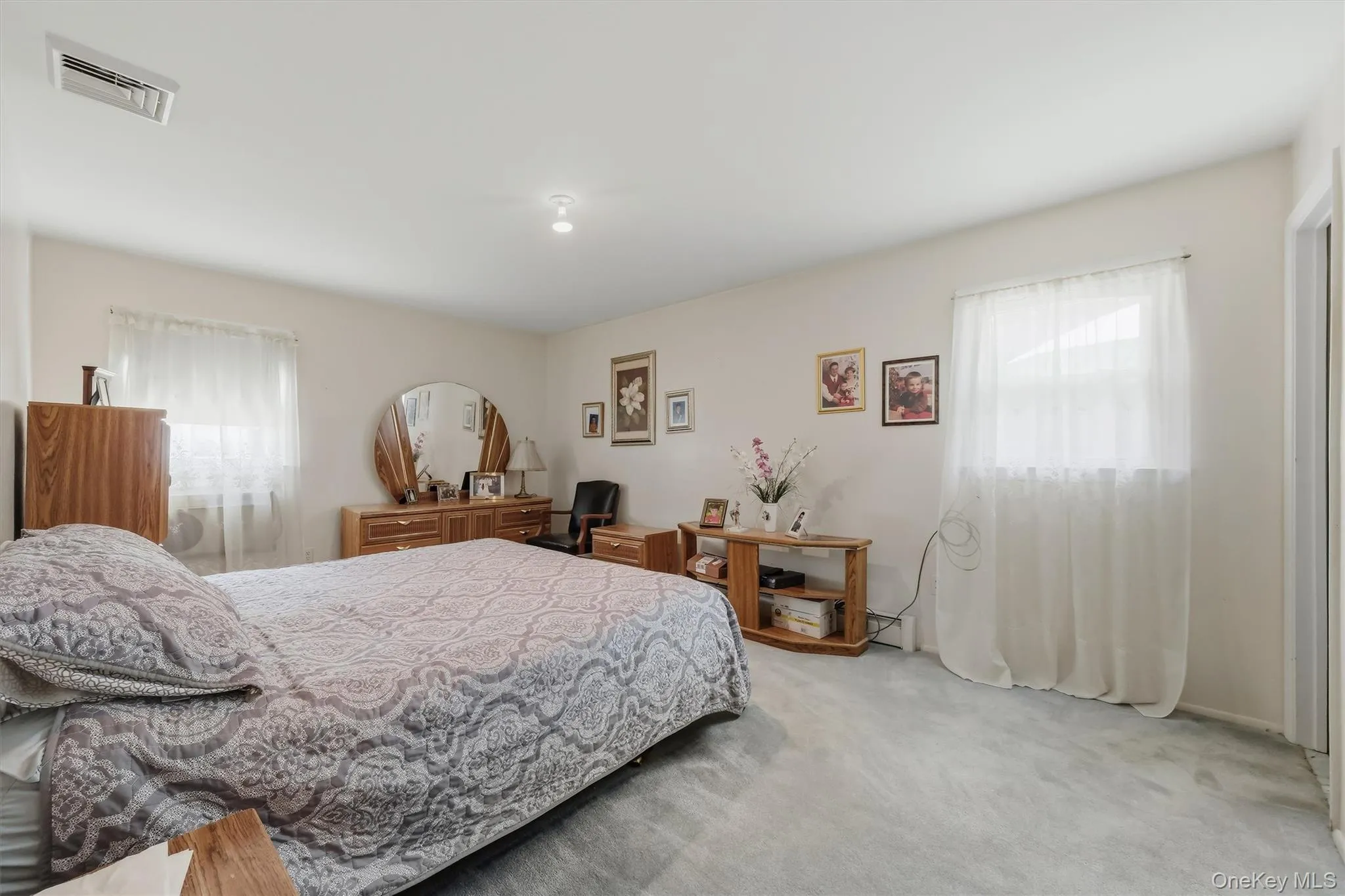 Generous sized primary with hardwood flooring underneath carpeting Generous sized primary with hardwood flooring underneath carpeting