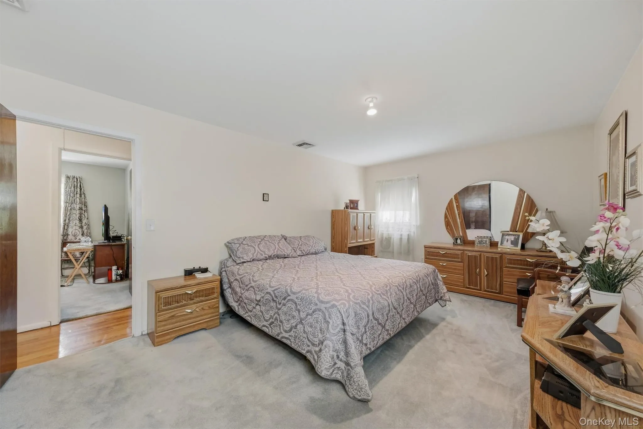 Generous sized primary with hardwood flooring underneath carpeting Generous sized primary with hardwood flooring underneath carpeting