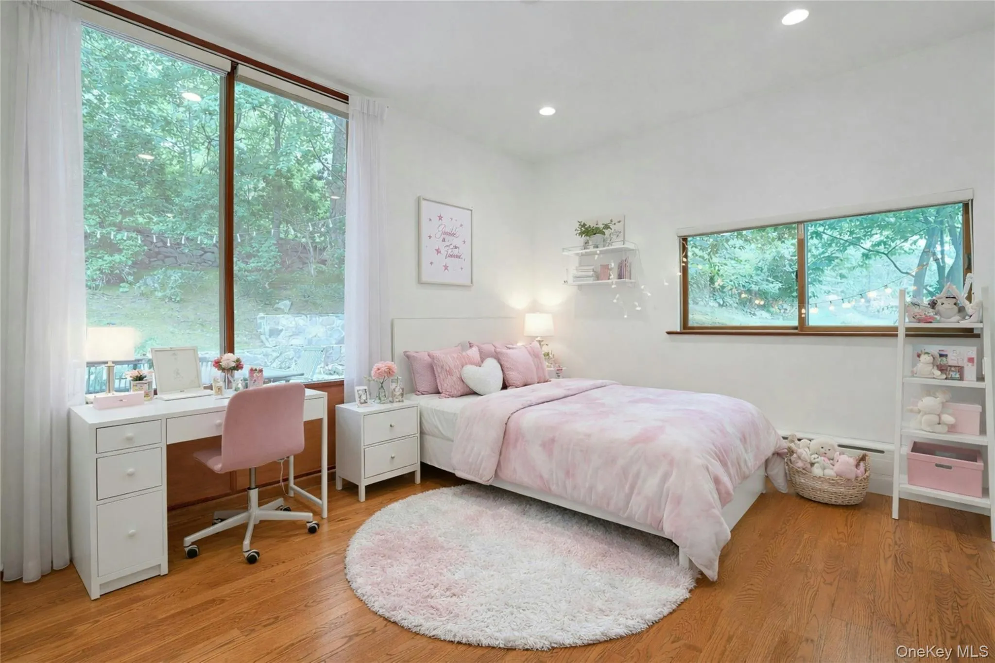 Another generously sized bedroom filled with natural light, offering hardwood floors, expansive picture windows, and a flexible layout perfect for family, guests, or a home office. (Digitally staged.) Another generously sized bedroom filled with natural light, offering hardwood floors, expansive picture windows, and a flexible layout perfect for family, guests, or a home office. (Digitally staged.)