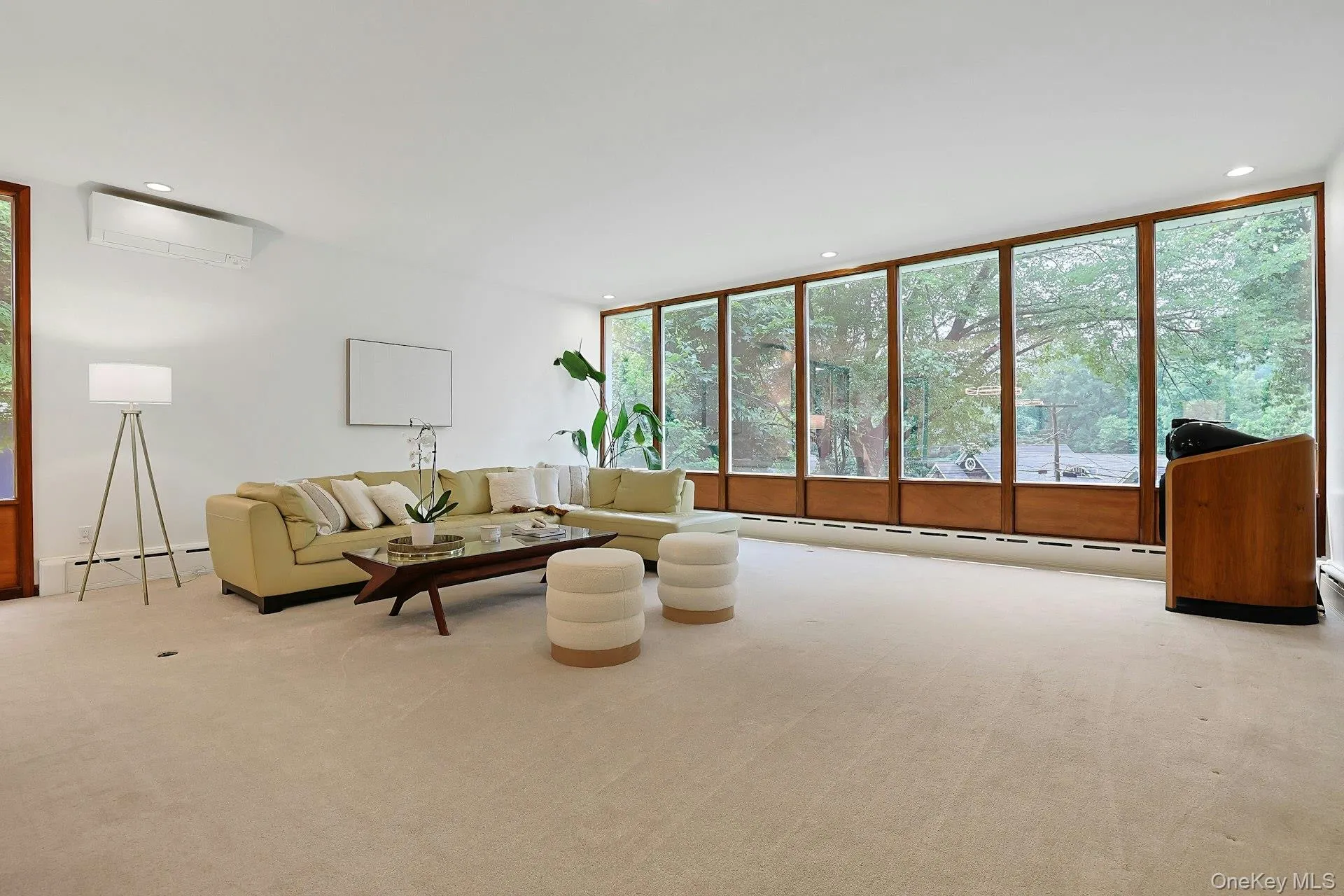 The expansive living room is bathed in natural light, where dramatic walls of glass blur the lines between indoors and the surrounding landscape. The expansive living room is bathed in natural light, where dramatic walls of glass blur the lines between indoors and the surrounding landscape.