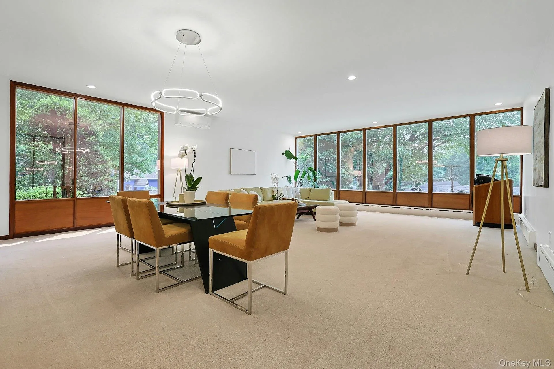 Expansive open-concept living and dining spaces are wrapped in walls of glass, creating an airy atmosphere with tranquil wooded views in every direction. Expansive open-concept living and dining spaces are wrapped in walls of glass, creating an airy atmosphere with tranquil wooded views in every direction.