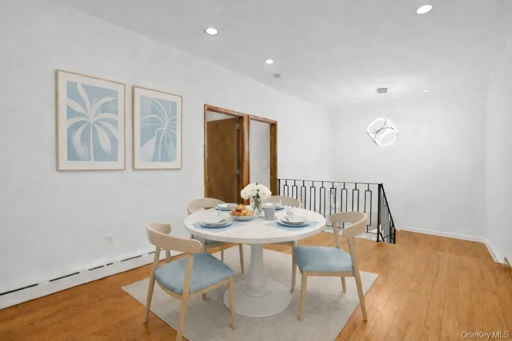 The inviting dining area features sliding doors to the patio, creating an ideal setting for everyday meals and effortless indoor-outdoor entertaining. The open stairwell provides access to the versatile lower level. (DIgitally Staged.) The inviting dining area features sliding doors to the patio, creating an ideal setting for everyday meals and effortless indoor-outdoor entertaining. The open stairwell provides access to the versatile lower level. (DIgitally Staged.)