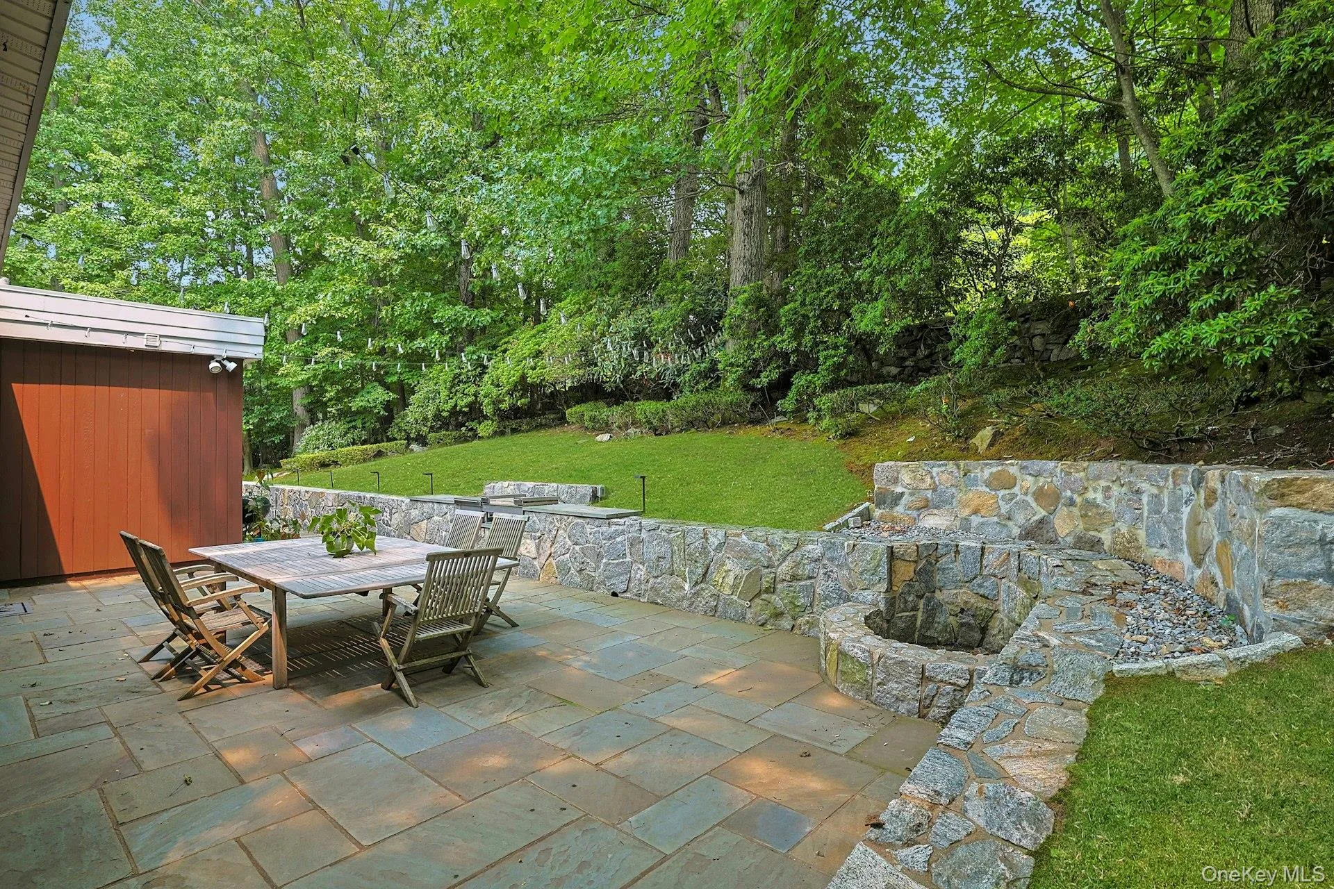 The expansive stone patio offers the perfect setting for al fresco dining, entertaining, or simply enjoying the peaceful wooded surroundings. The expansive stone patio offers the perfect setting for al fresco dining, entertaining, or simply enjoying the peaceful wooded surroundings.