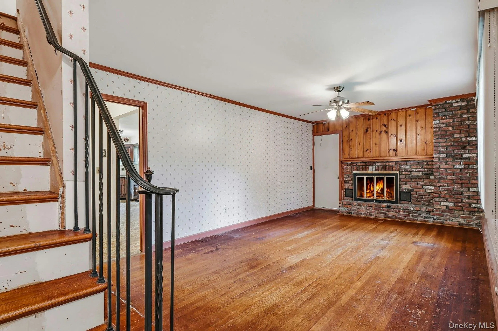 Hardwood floors and wood burning fireplace with stairs going up to second level Hardwood floors and wood burning fireplace with stairs going up to second level