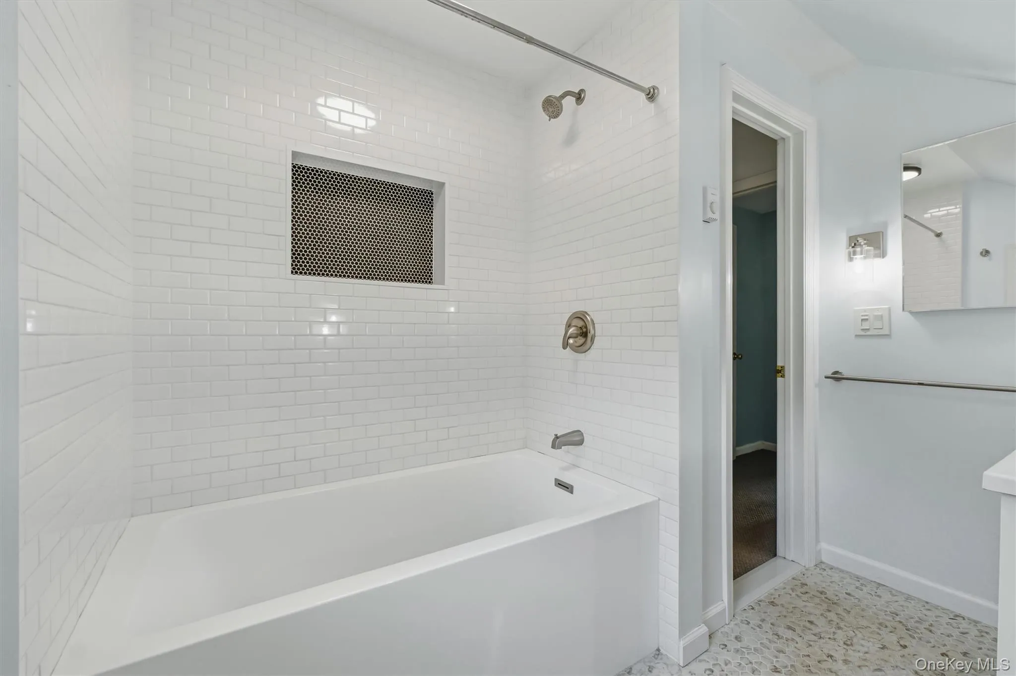 Bathtub with subway tile surround, integrated shower niche, and brushed nickel fixtures Bathtub with subway tile surround, integrated shower niche, and brushed nickel fixtures