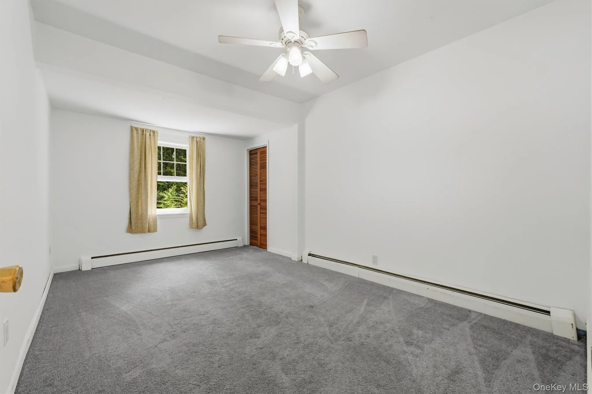 Spacious room featuring light gray carpeting, neutral wall paint, and a ceiling fan Spacious room featuring light gray carpeting, neutral wall paint, and a ceiling fan