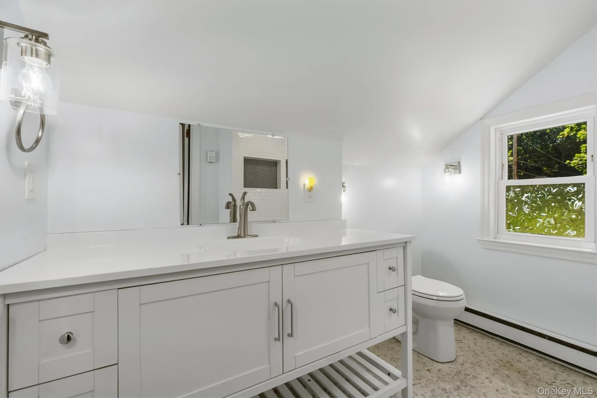 White vanity with an integrated sink and brushed nickel faucet White vanity with an integrated sink and brushed nickel faucet
