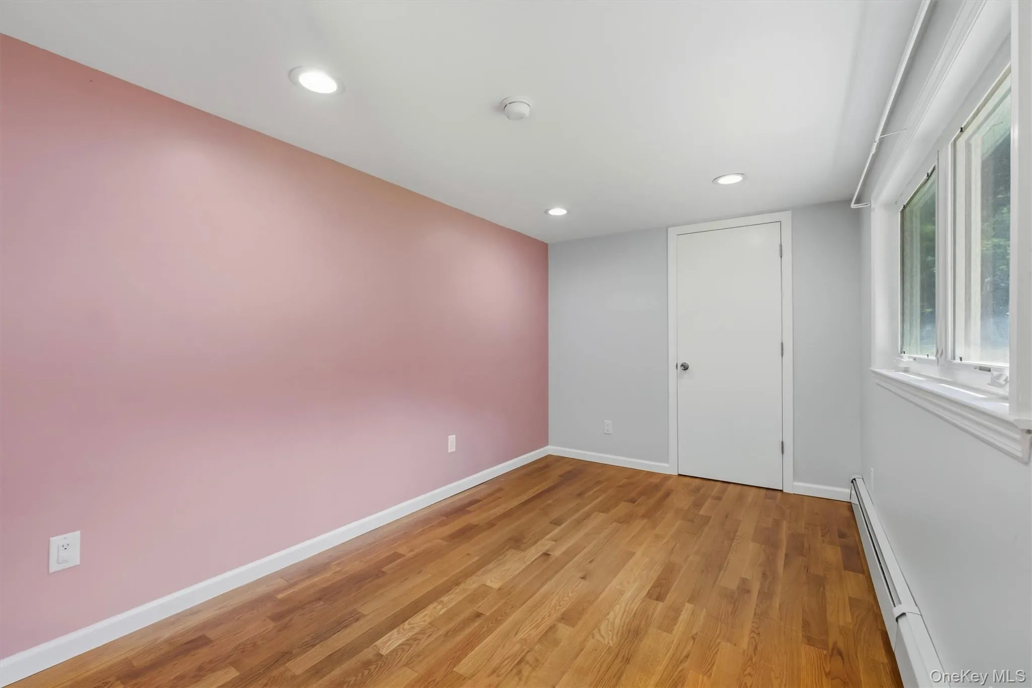Office with hardwood flooring with a matte finish, recessed lighting, and a white-trimmed window Office with hardwood flooring with a matte finish, recessed lighting, and a white-trimmed window