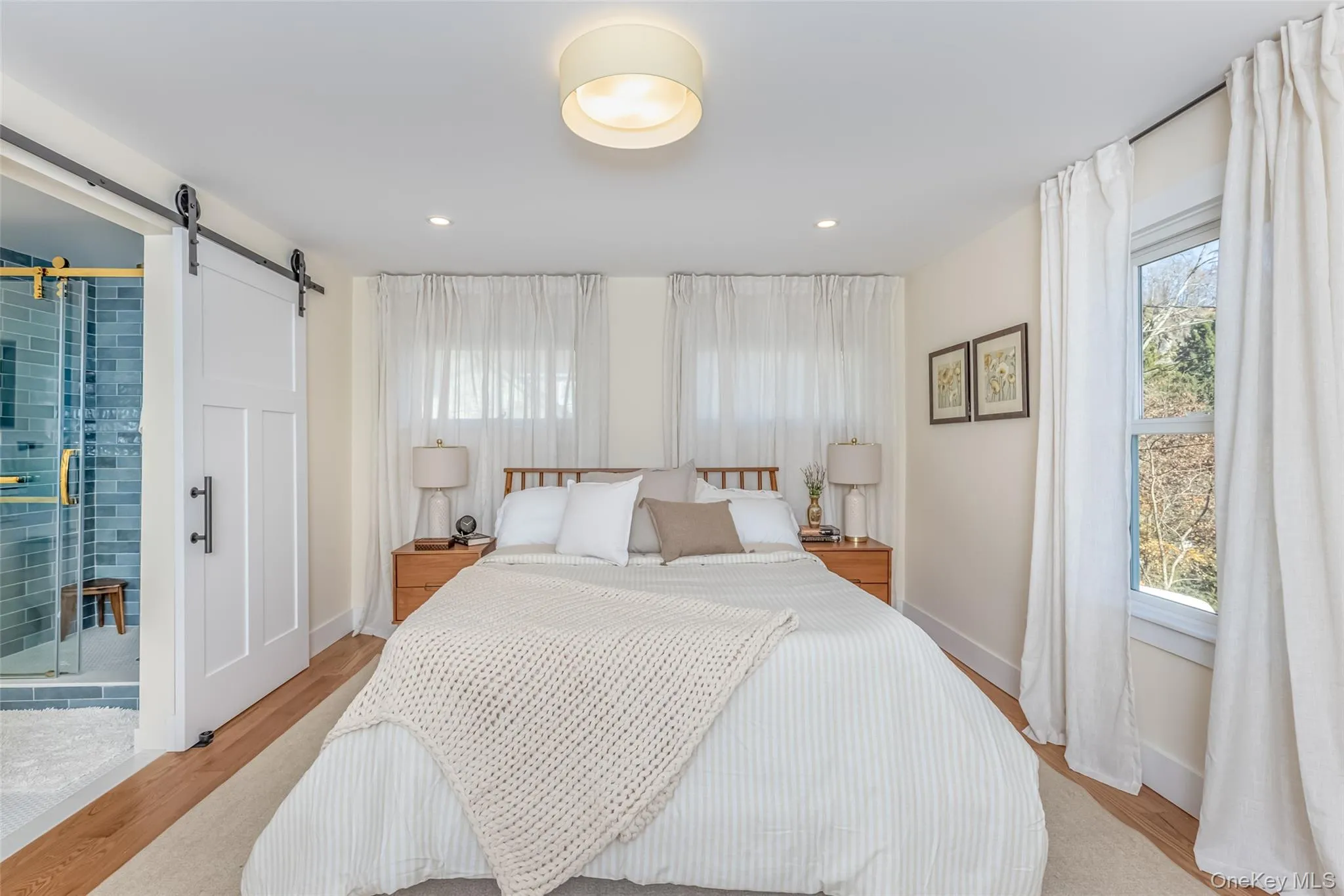 Bedroom with a barn door and light hardwood / wood-style flooring Bedroom with a barn door and light hardwood / wood-style flooring