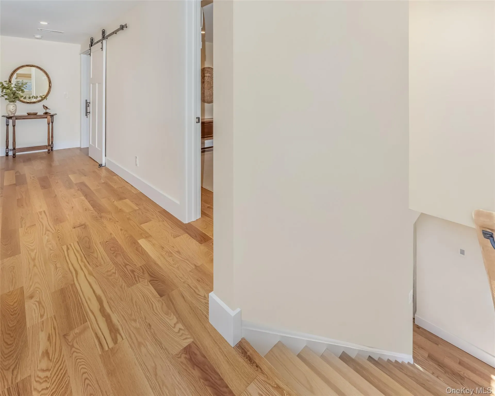 Hall featuring a barn door and light hardwood / wood-style floors Hall featuring a barn door and light hardwood / wood-style floors