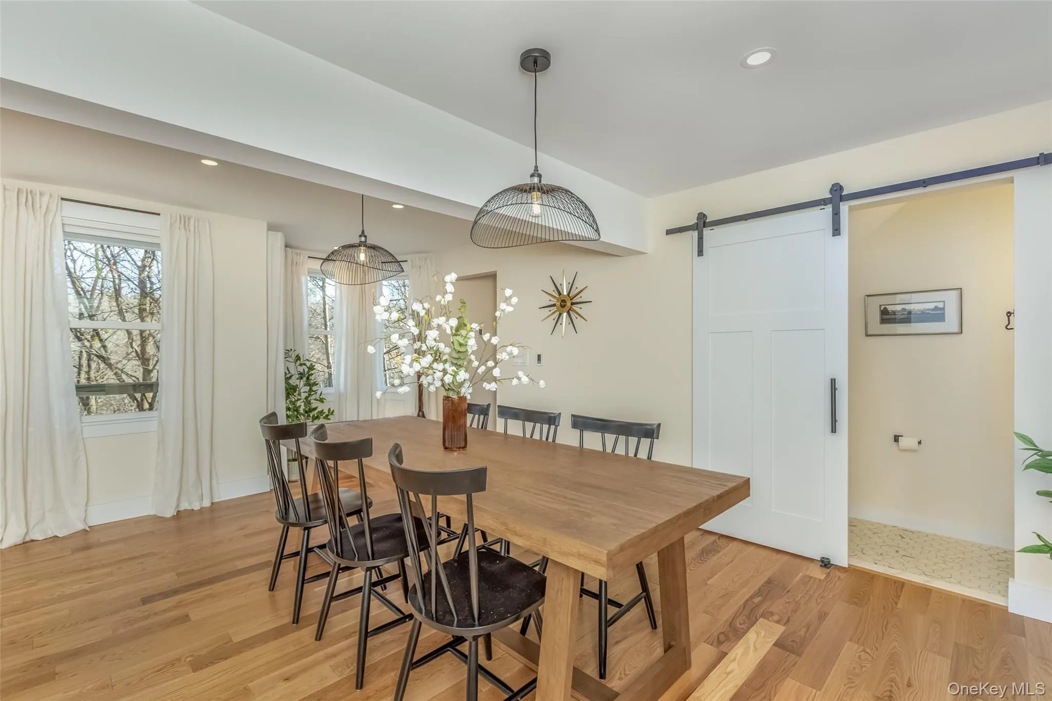 Dining room featuring a barn door and light wood-type flooring Dining room featuring a barn door and light wood-type flooring