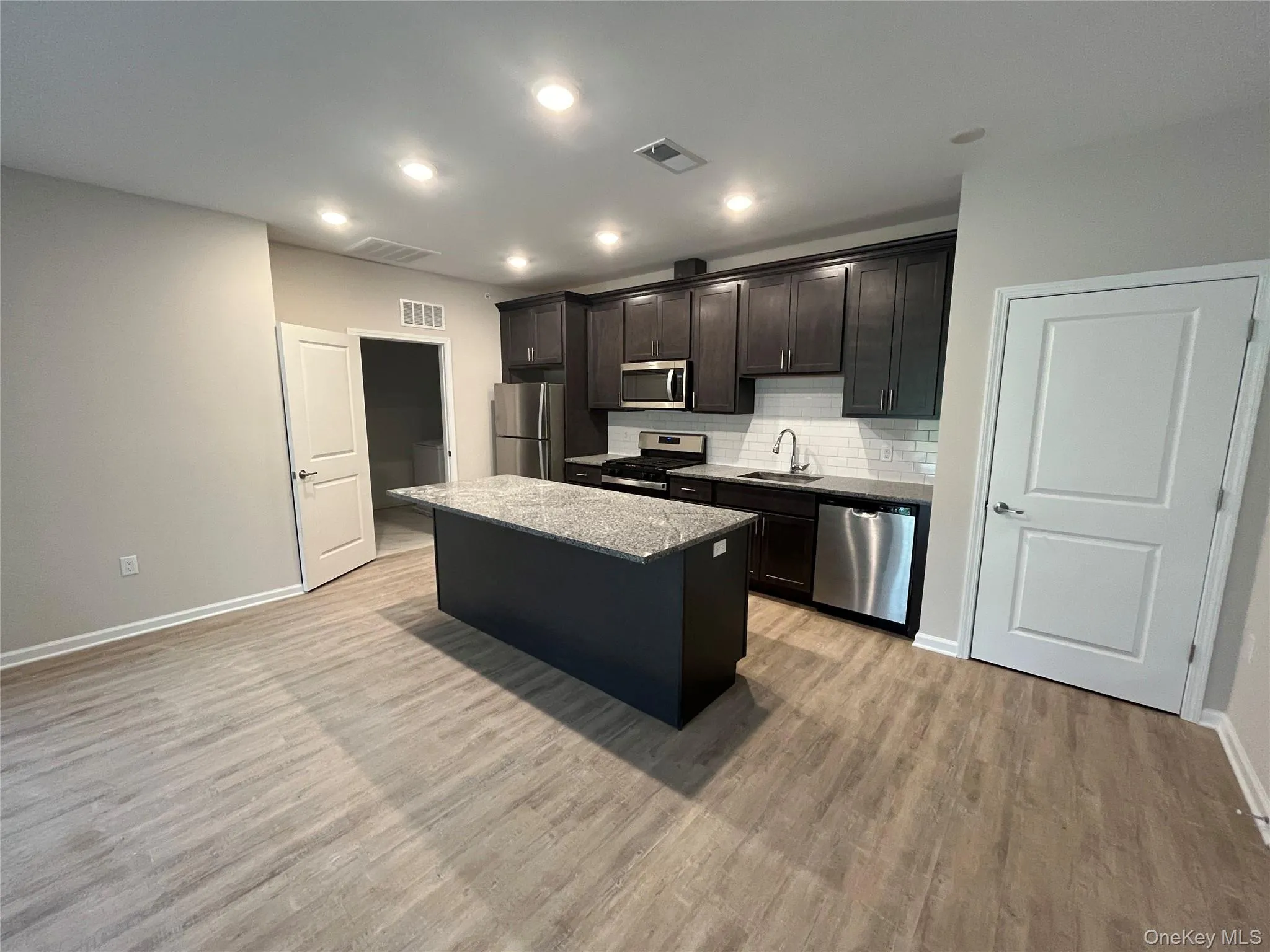 Tower Ridge Grande – Elegant open-concept kitchen with a spacious center island, stainless steel appliances, upscale cabinetry, recessed lighting, and luxury plank flooring. Designed for both style and functionalit Tower Ridge Grande – Elegant open-concept kitchen with a spacious center island, stainless steel appliances, upscale cabinetry, recessed lighting, and luxury plank flooring. Designed for both style and functionalit
