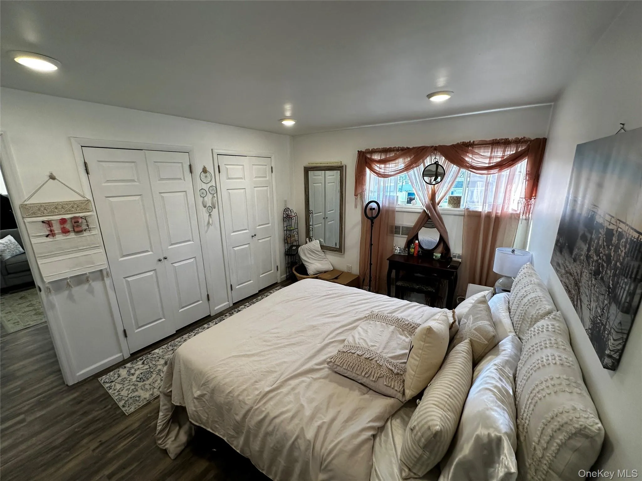 Room featuring wood-finish flooring, two sets of bi-fold closet doors, and recessed ceiling lighting Room featuring wood-finish flooring, two sets of bi-fold closet doors, and recessed ceiling lighting