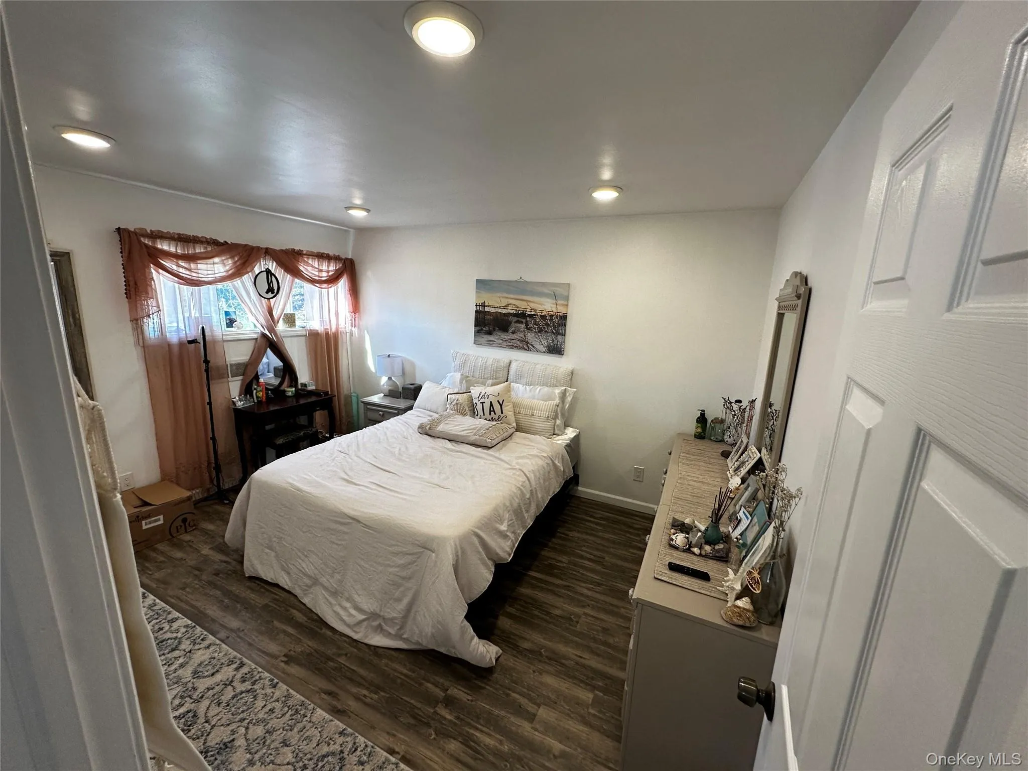 Bedroom featuring wood-finish flooring, recessed lighting, and a window with natural light Bedroom featuring wood-finish flooring, recessed lighting, and a window with natural light