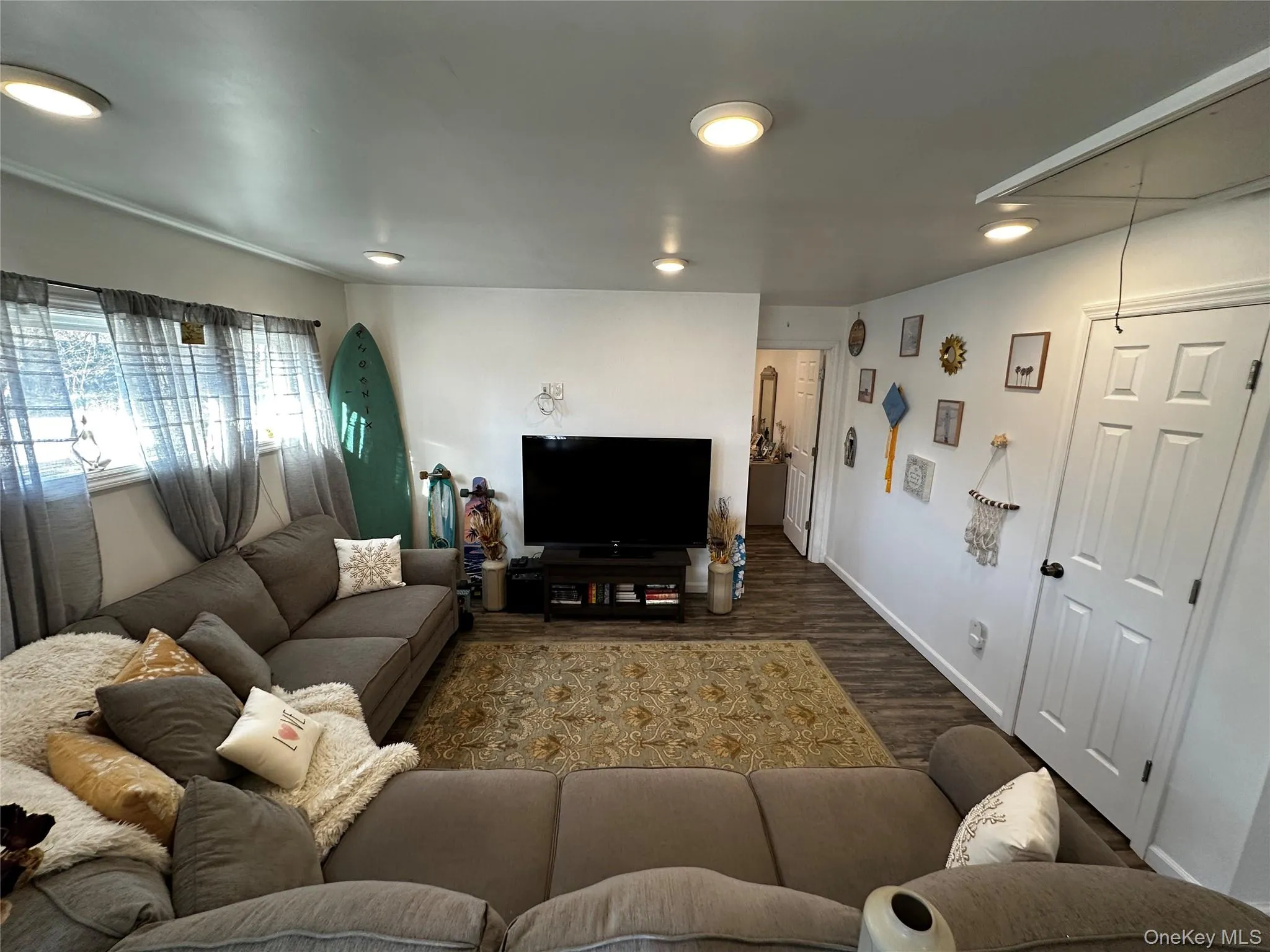 Living area featuring wood-finish flooring, recessed lighting, and multiple windows with valances Living area featuring wood-finish flooring, recessed lighting, and multiple windows with valances