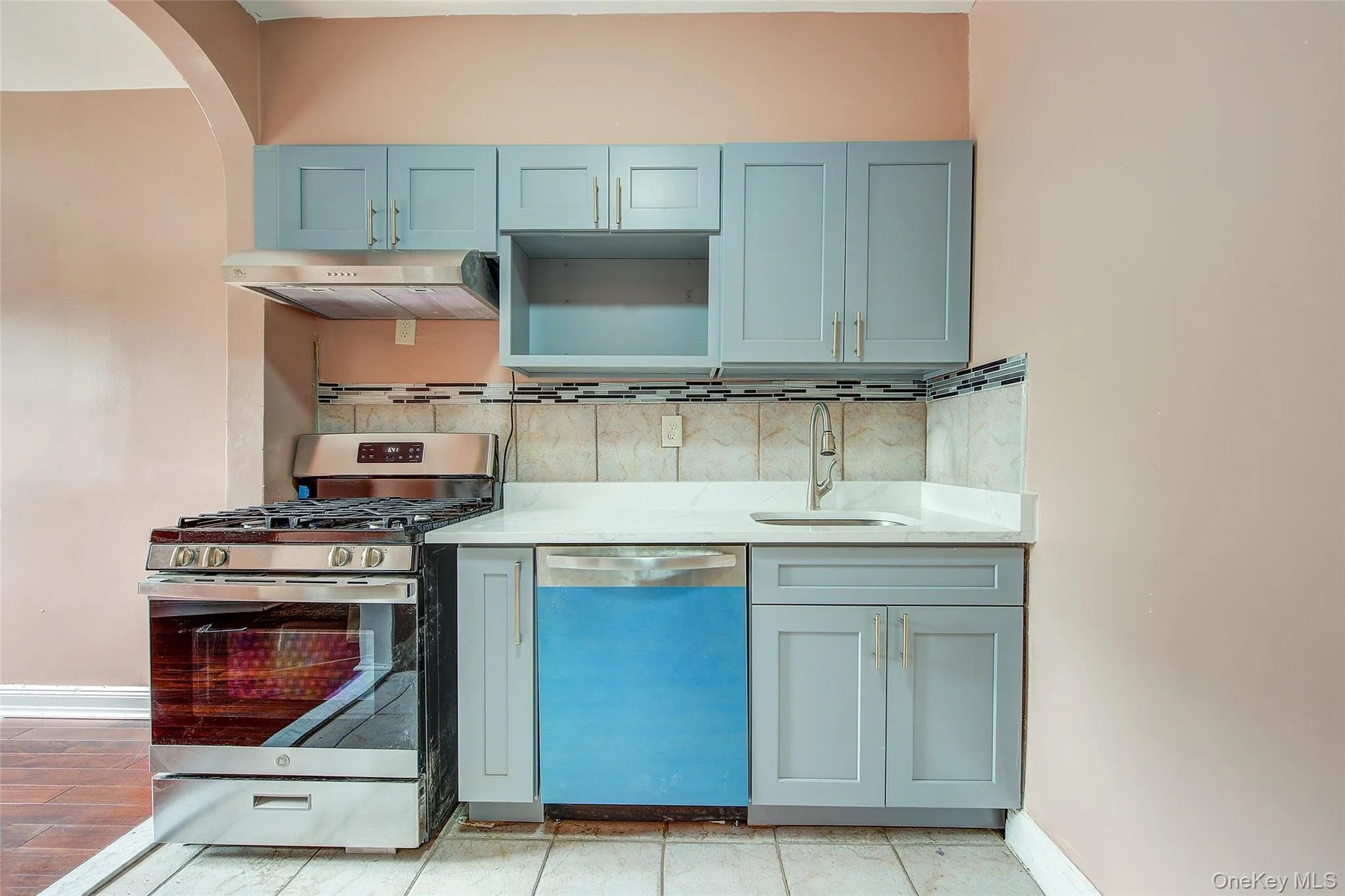 granite countertop, whirlpool stove, and dishwasher, tiled walls, gray on gold cabinets granite countertop, whirlpool stove, and dishwasher, tiled walls, gray on gold cabinets
