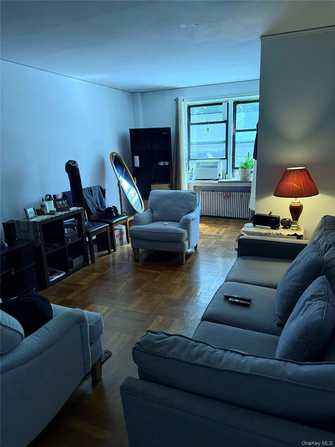 Parquet wood-finish flooring, multiple windows providing natural light, and a built-in air conditioning unit Parquet wood-finish flooring, multiple windows providing natural light, and a built-in air conditioning unit