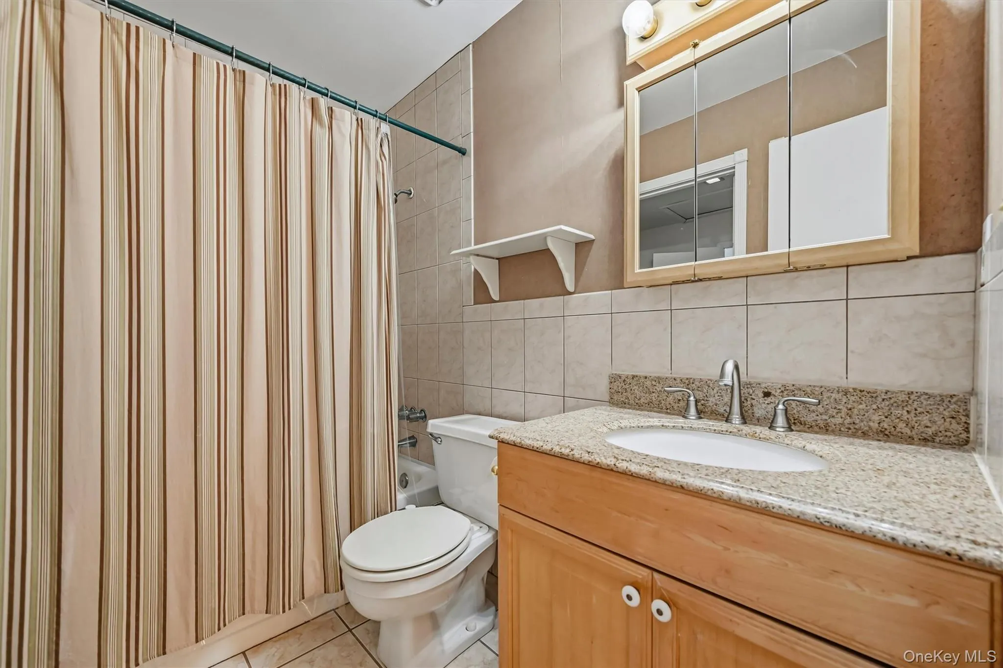 The bathroom has a granite vanity and a shower/tub. The bathroom has a granite vanity and a shower/tub.