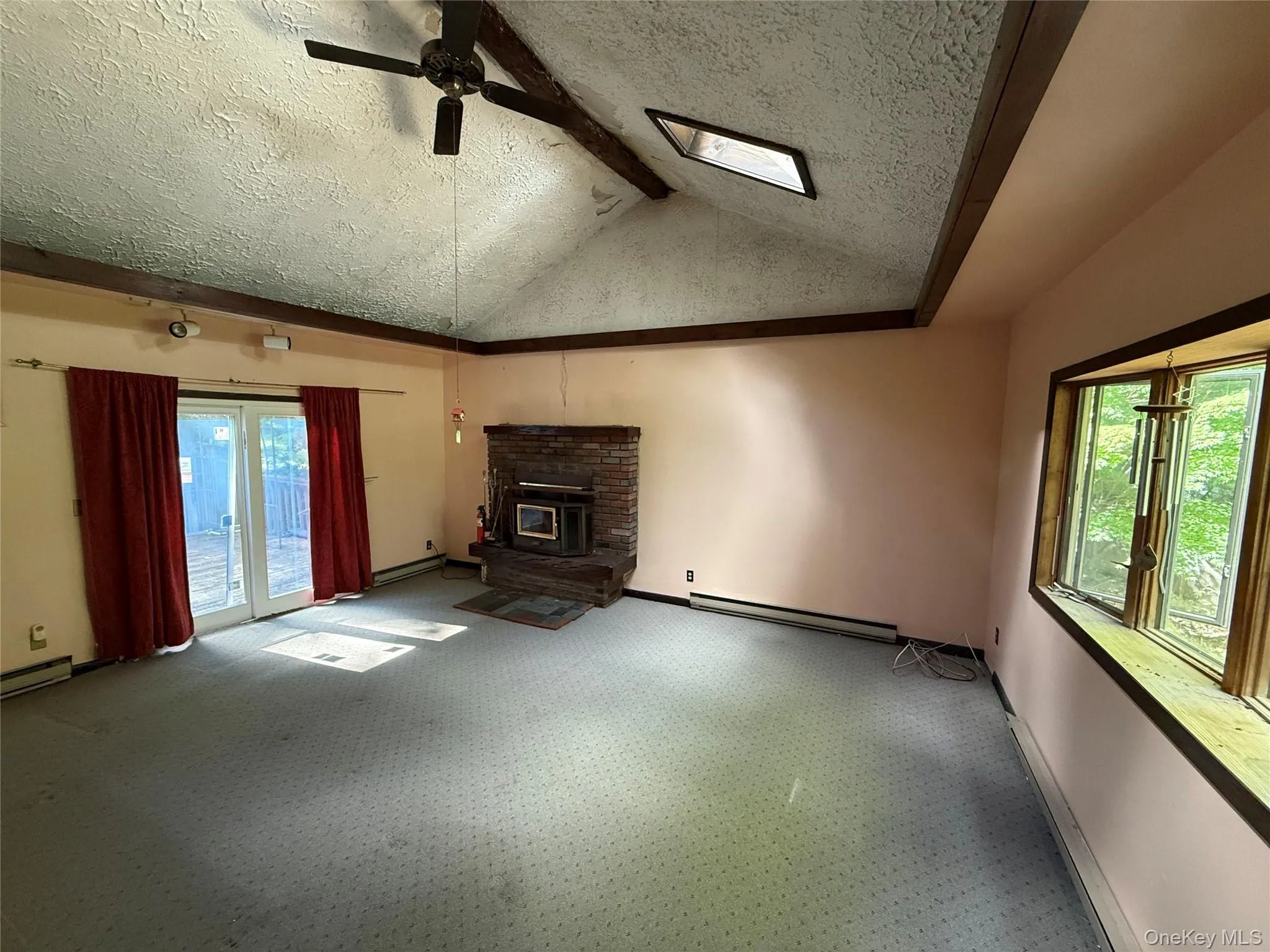 Living room containing vaulted ceilings, brick fire place with wood-burning insert and a walkout slider to the back deck. Living room containing vaulted ceilings, brick fire place with wood-burning insert and a walkout slider to the back deck.
