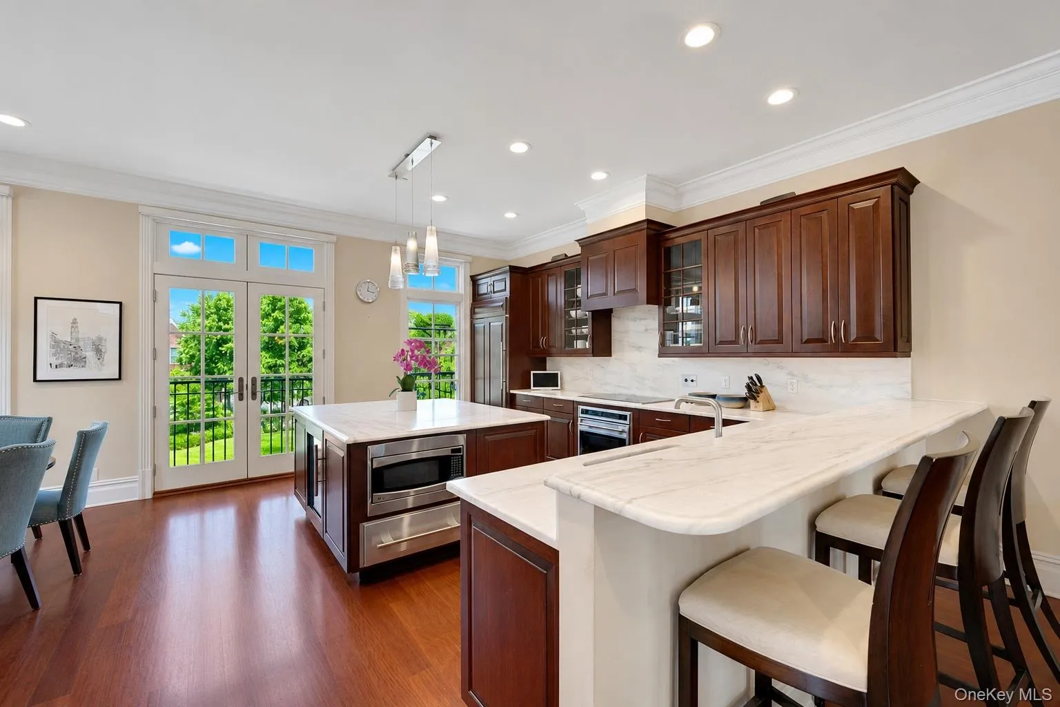 Eat-in chef's kitchen with Wolf induction over&cooktop, SubZero refrigerator, marble counters and island, floor to ceiling windows, and breakfast nook Eat-in chef's kitchen with Wolf induction over&cooktop, SubZero refrigerator, marble counters and island, floor to ceiling windows, and breakfast nook