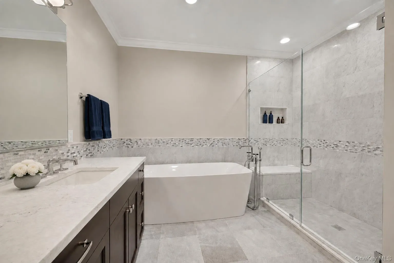 Beautiful marble tile work and spa features in large glass shower Beautiful marble tile work and spa features in large glass shower