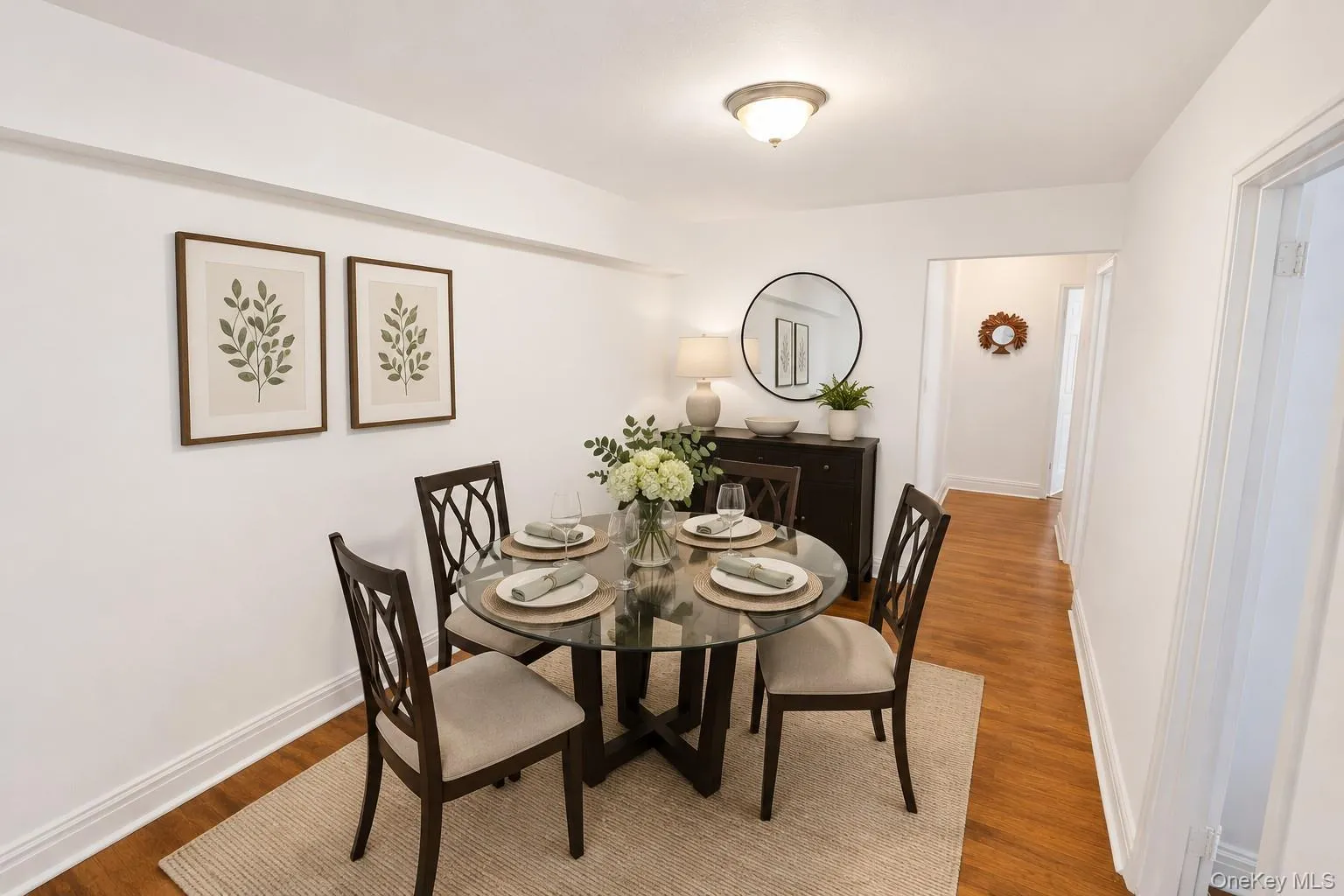 Dining area featuring wood-finish flooring, white baseboards, and a semi-flush ceiling light fixture Dining area featuring wood-finish flooring, white baseboards, and a semi-flush ceiling light fixture