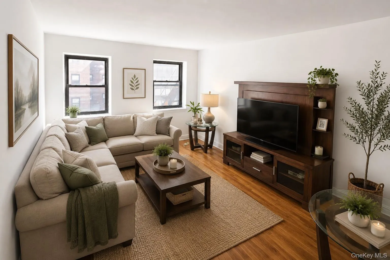 Spacious living area featuring warm wood-finish flooring, white walls, and dark-framed windows Spacious living area featuring warm wood-finish flooring, white walls, and dark-framed windows