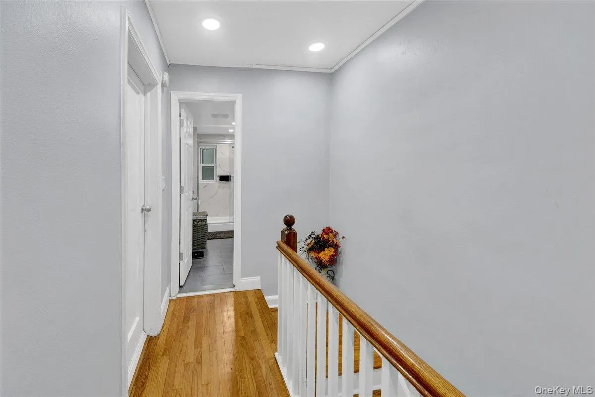 Hardwood flooring throughout a hallway with white doors and recessed lighting Hardwood flooring throughout a hallway with white doors and recessed lighting