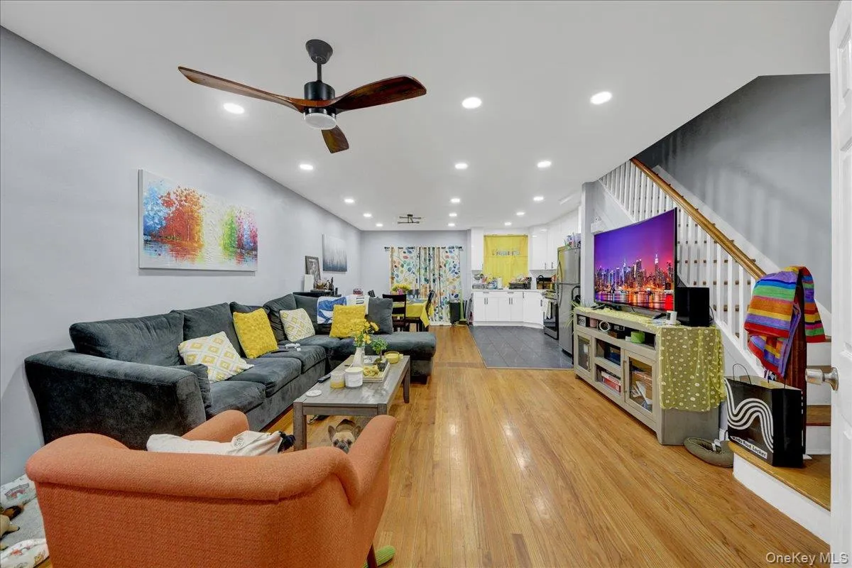 Open-concept living area featuring wood-finish flooring, recessed lighting, and a ceiling fan Open-concept living area featuring wood-finish flooring, recessed lighting, and a ceiling fan