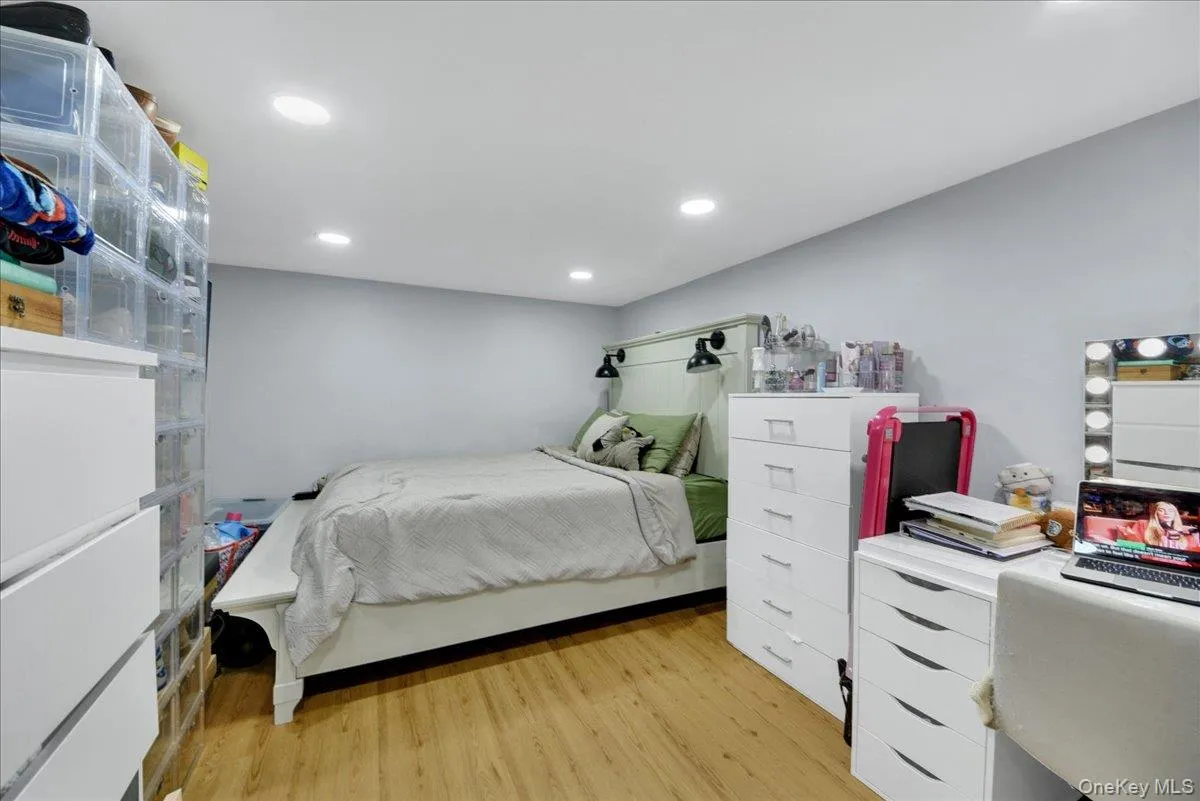 Bedroom featuring wood-finish flooring, recessed lighting, and light grey wall paint Bedroom featuring wood-finish flooring, recessed lighting, and light grey wall paint