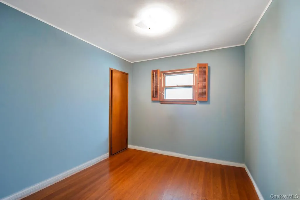 Room featuring wood-finish flooring and light blue walls Room featuring wood-finish flooring and light blue walls