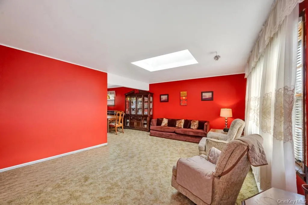 Expansive room with neutral-toned carpet flooring and vibrant red walls Expansive room with neutral-toned carpet flooring and vibrant red walls