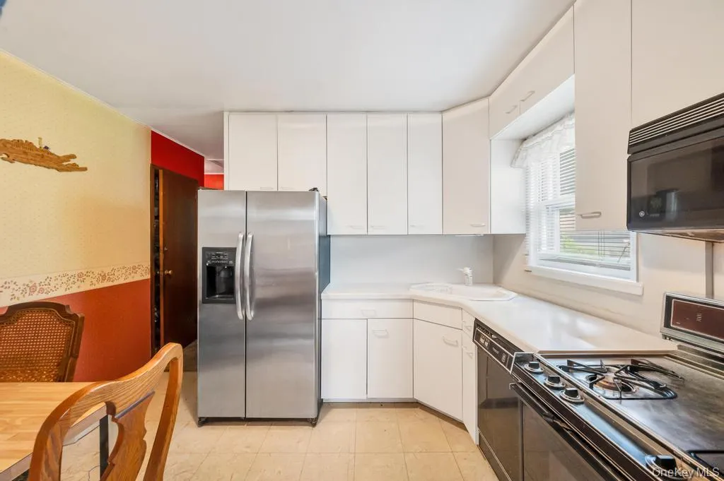 Kitchen featuring white cabinetry, light-toned countertops, tile flooring, a stainless steel side-by-side refrigerator, and a built-in oven with stovetop Kitchen featuring white cabinetry, light-toned countertops, tile flooring, a stainless steel side-by-side refrigerator, and a built-in oven with stovetop