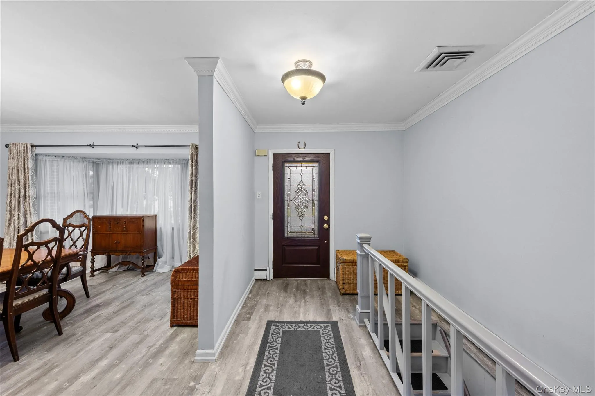 Entryway featuring a dark wood door with decorative glass inserts, flush mount lighting, and crown molding Entryway featuring a dark wood door with decorative glass inserts, flush mount lighting, and crown molding