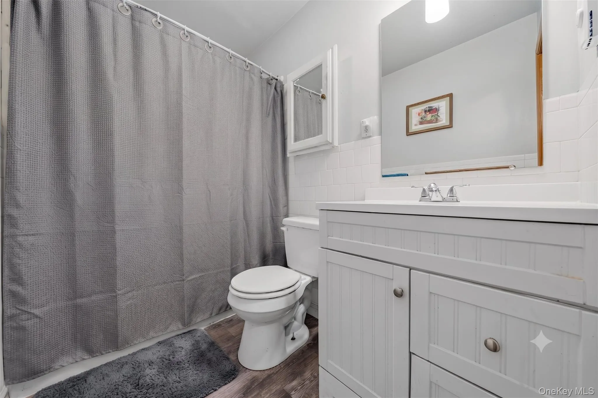 Convenient full bathroom featuring a tub-and-shower combination, vanity, mirror, and storage cabinetry. Convenient full bathroom featuring a tub-and-shower combination, vanity, mirror, and storage cabinetry.