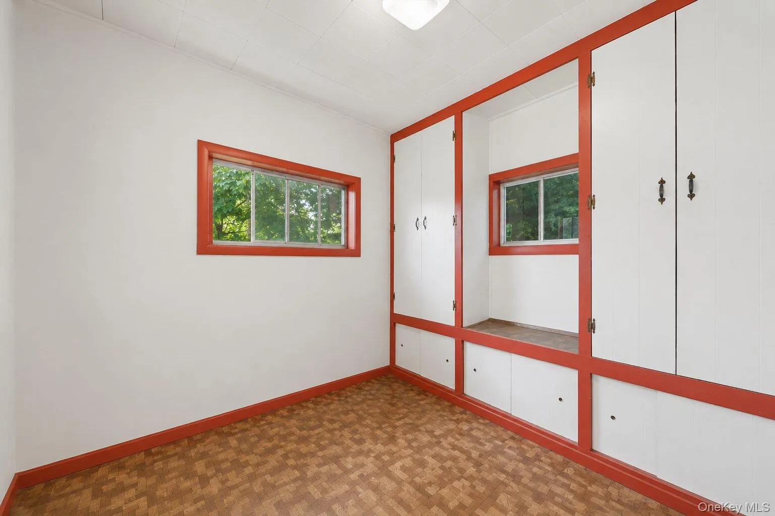Bonus Room: Bright bonus room with built-in cabinets, mirrored storage, distinctive red trim, and flexible space for an office, craft room, or playroom. Bonus Room: Bright bonus room with built-in cabinets, mirrored storage, distinctive red trim, and flexible space for an office, craft room, or playroom.