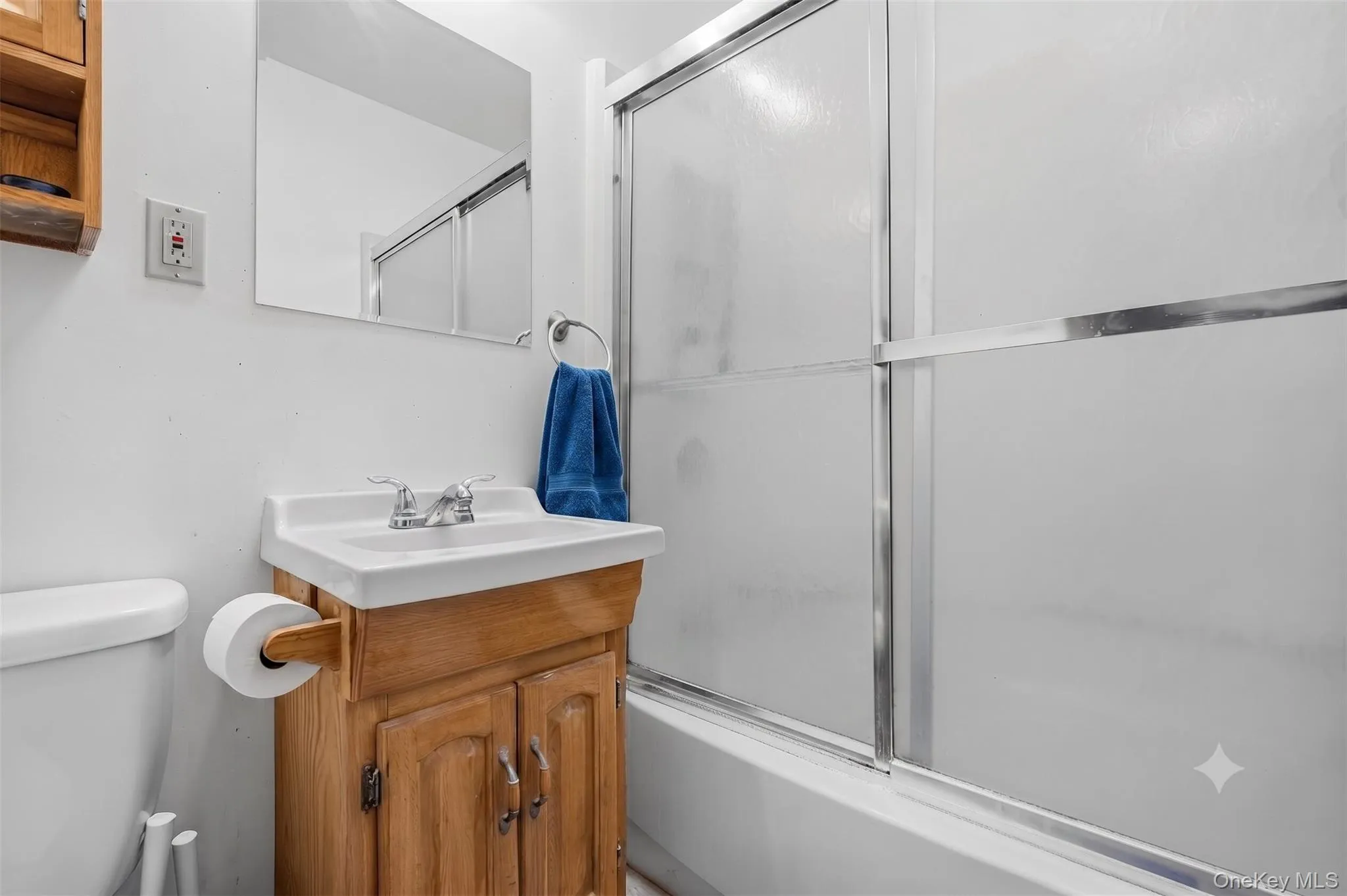 Bright full bathroom, tub-and-shower combination, tile surround, and wood-look flooring. Bright full bathroom, tub-and-shower combination, tile surround, and wood-look flooring.