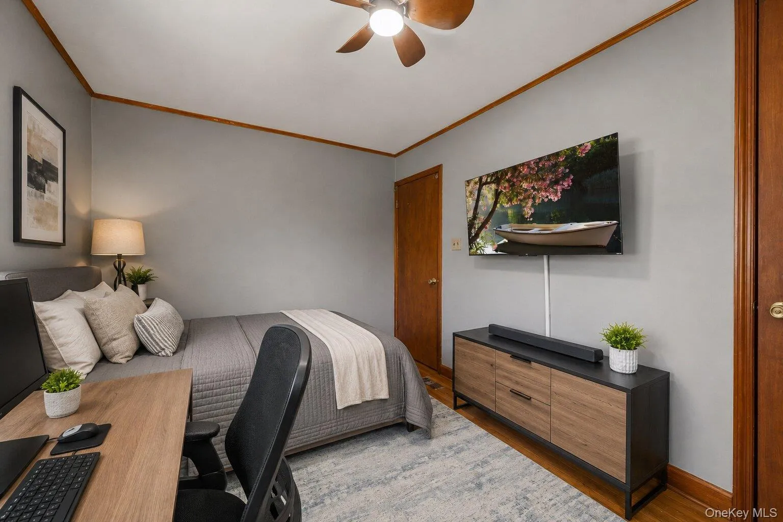 Virtually Staged Bedroom and Workspace: Additional view of the versatile bedroom featuring a bed, dresser, workstation, hardwood floors, and multiple windows. Virtually Staged Bedroom and Workspace: Additional view of the versatile bedroom featuring a bed, dresser, workstation, hardwood floors, and multiple windows.