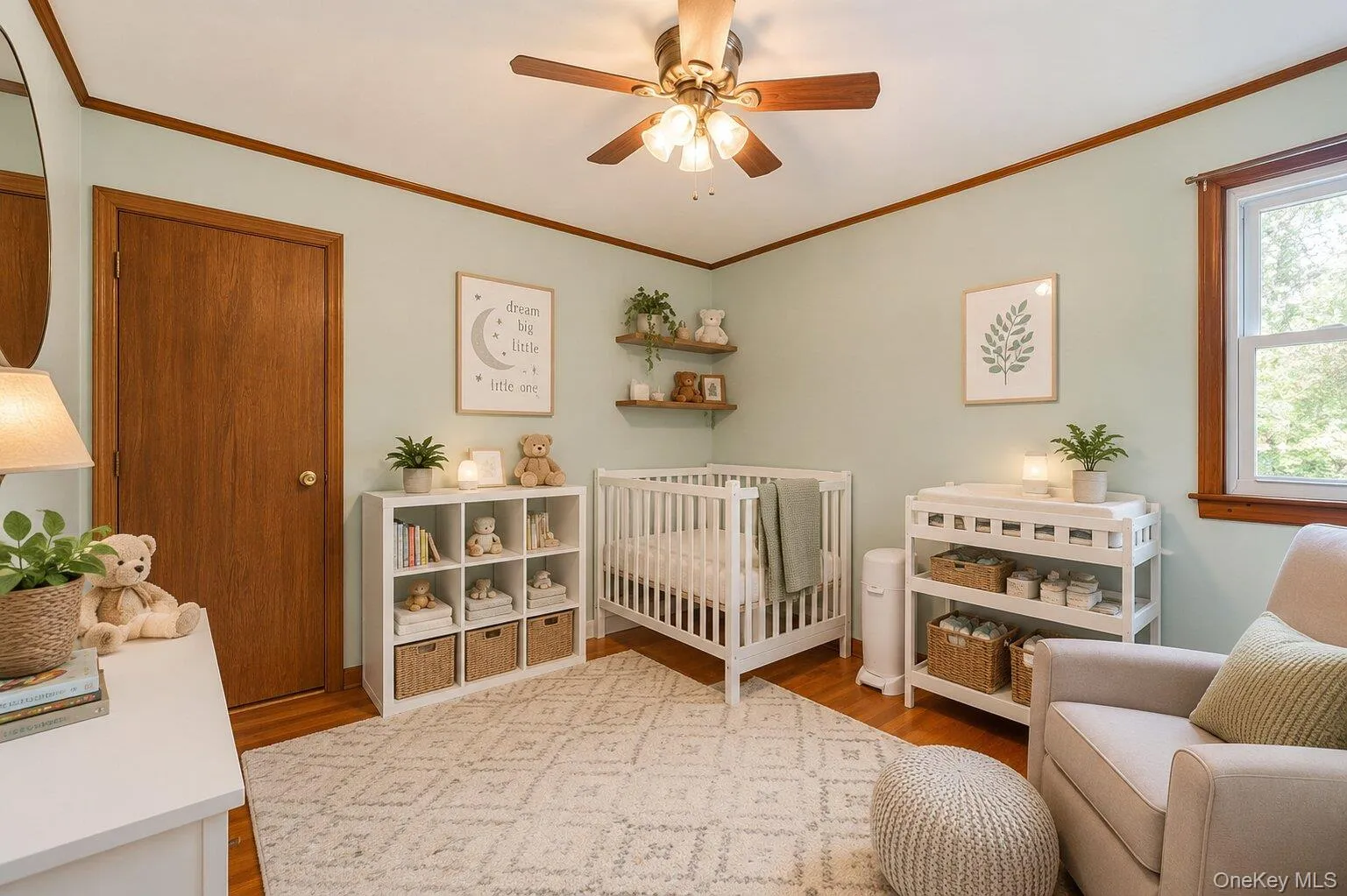 Virtually Staged Nursery: Bright bedroom shown as a peaceful nursery with hardwood floors, a ceiling fan, built-in closet storage, and natural light. Virtually Staged Nursery: Bright bedroom shown as a peaceful nursery with hardwood floors, a ceiling fan, built-in closet storage, and natural light.